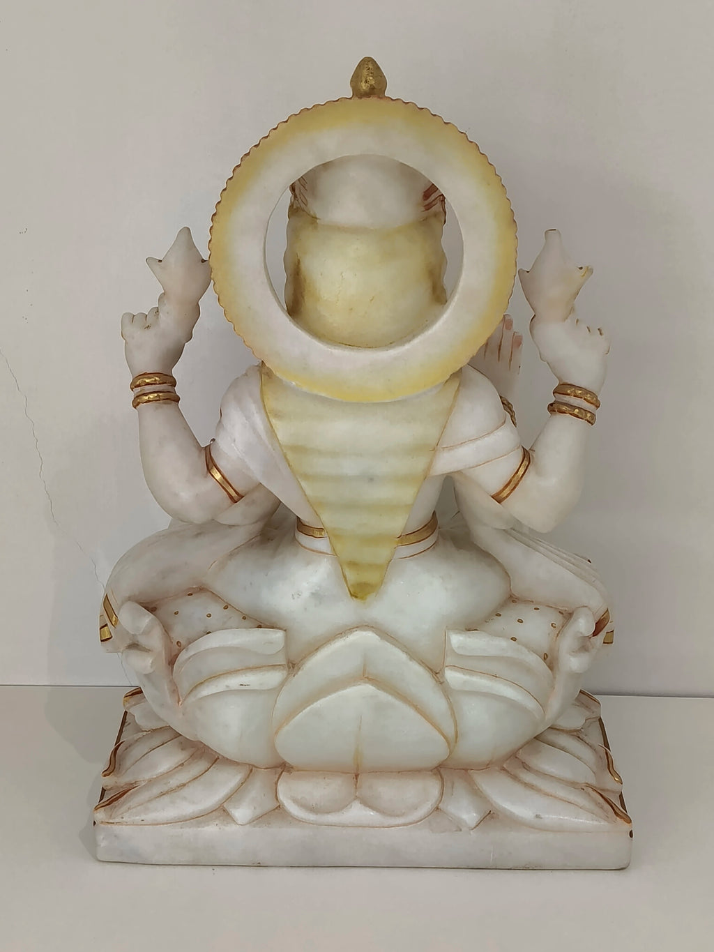 Back view of large marble statue of Goddess Lakshmi seated on lotus