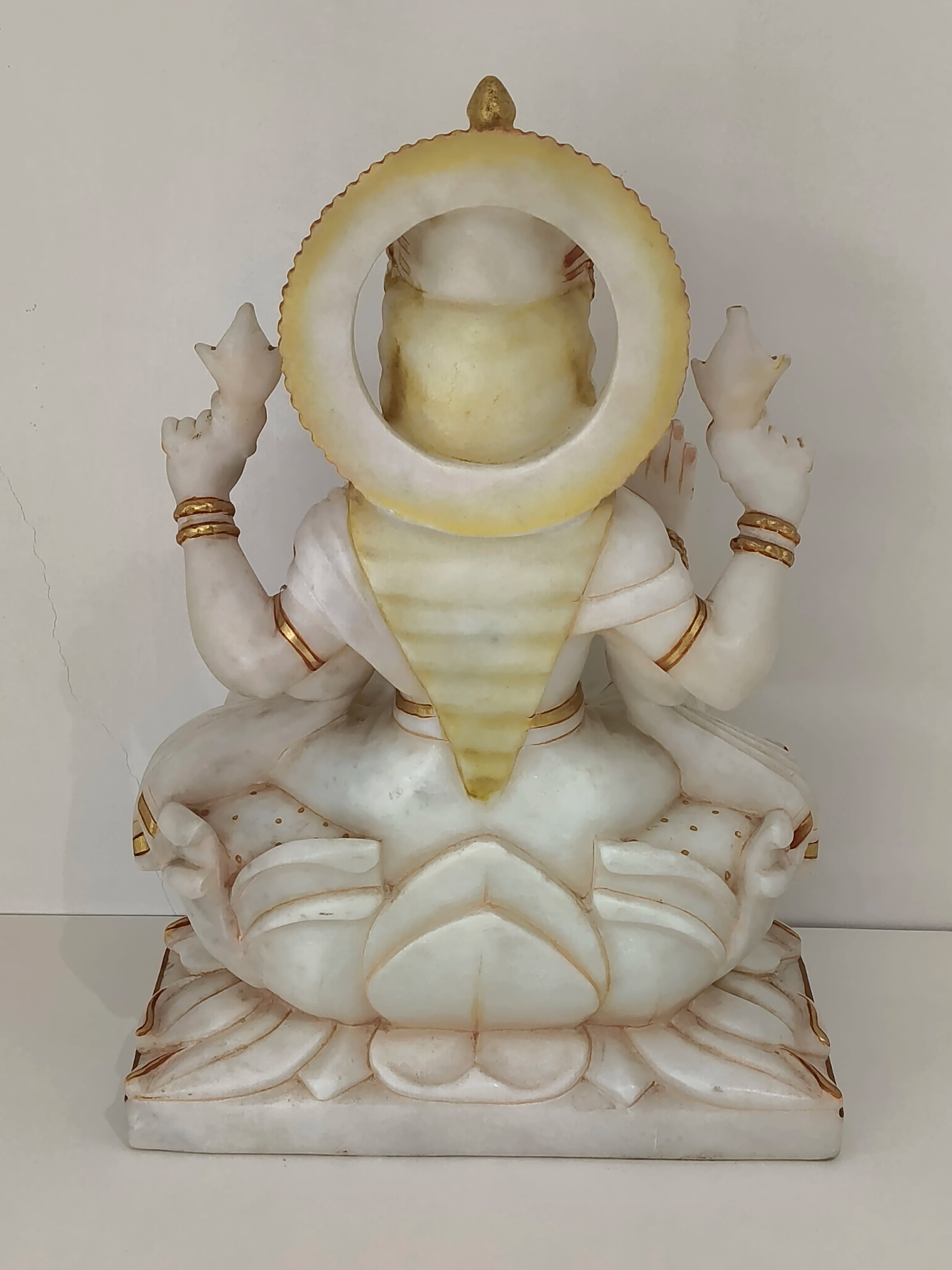Back view of large marble statue of Goddess Lakshmi seated on lotus