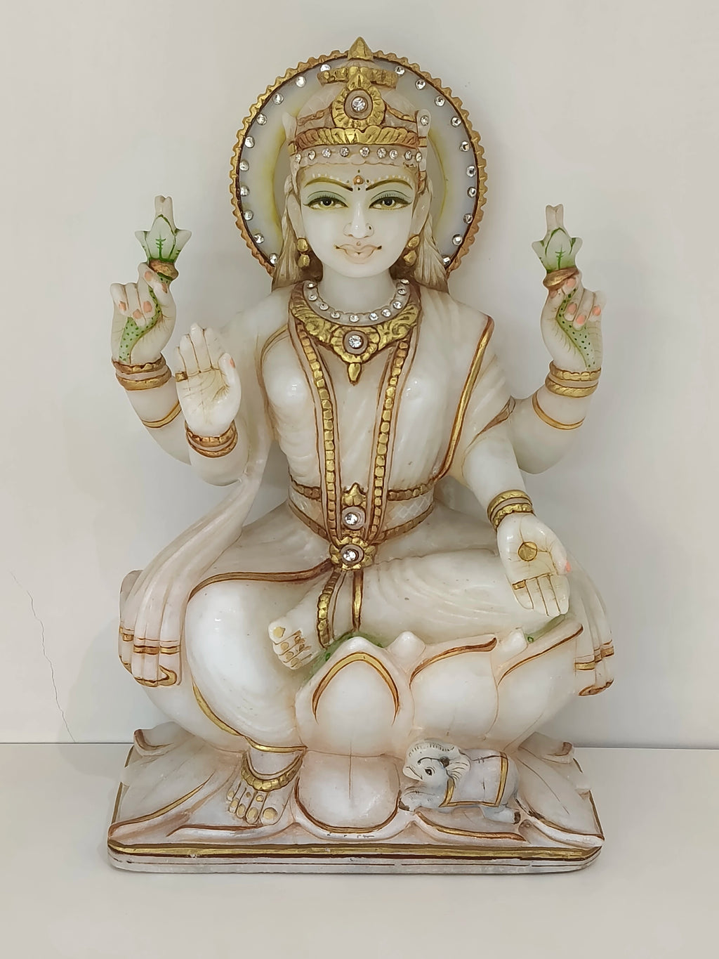 Large white marble Lakshmi statue with gold accents seated on lotus base