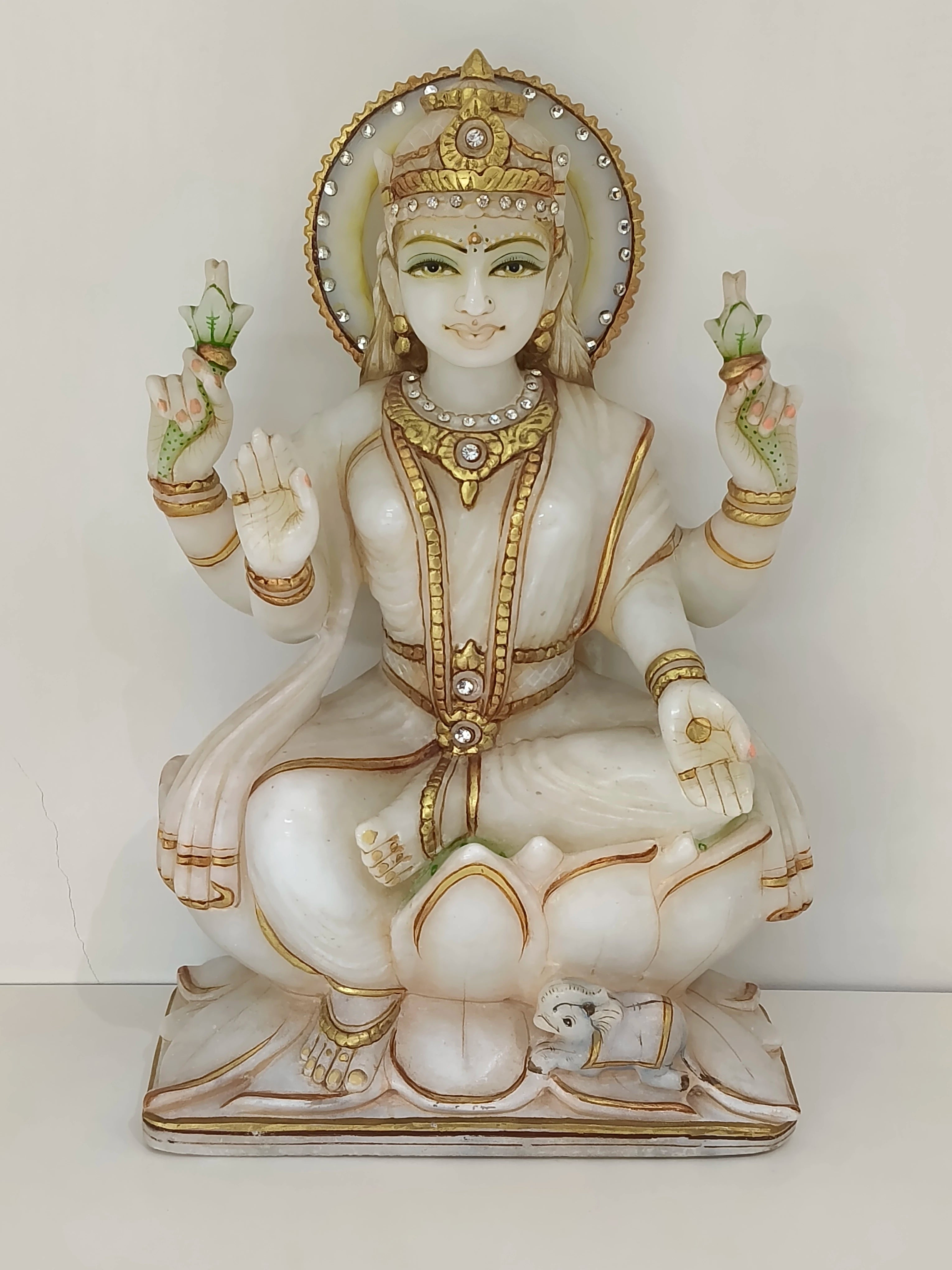 Large white marble Lakshmi statue with gold accents seated on lotus base