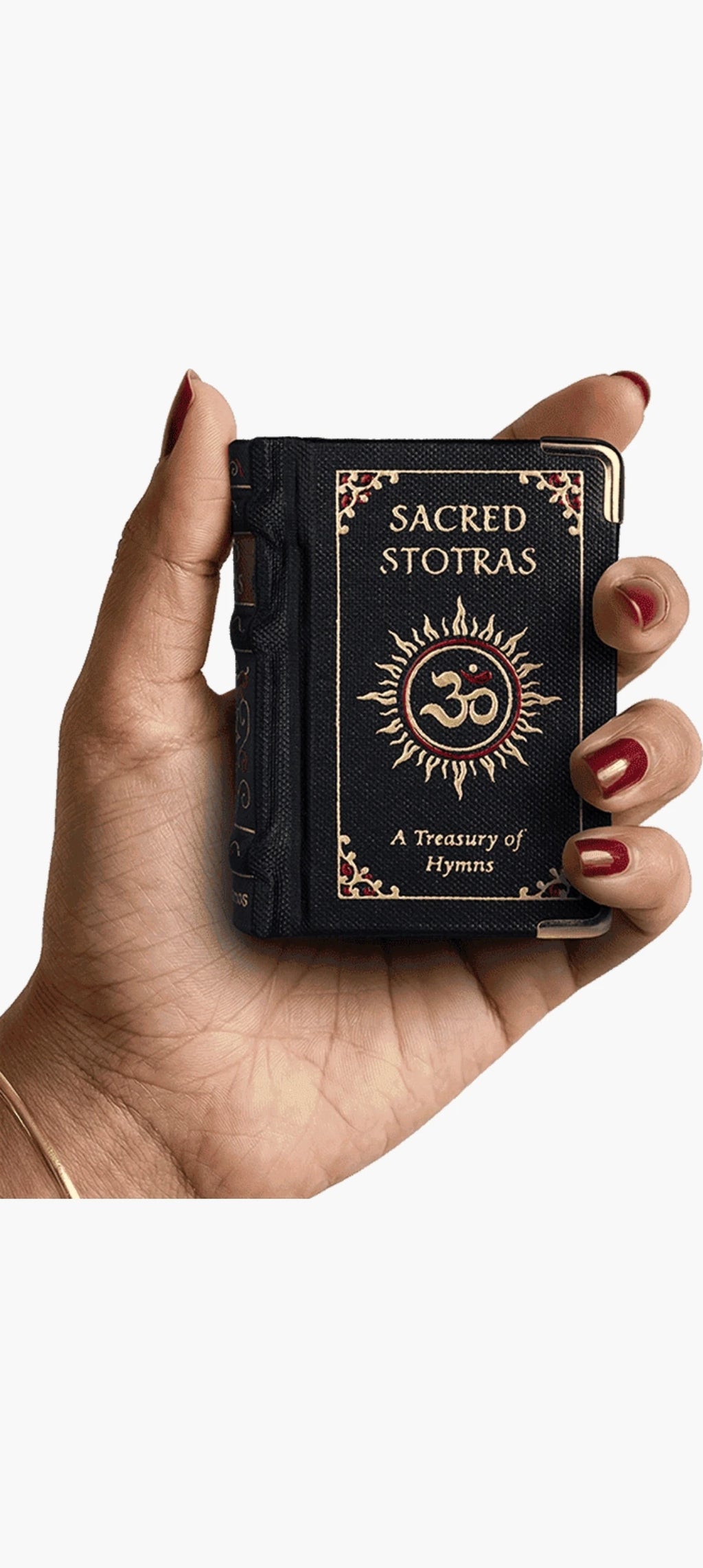 Small hardbound book titled Sacred Stotras held in hand with decorative cover