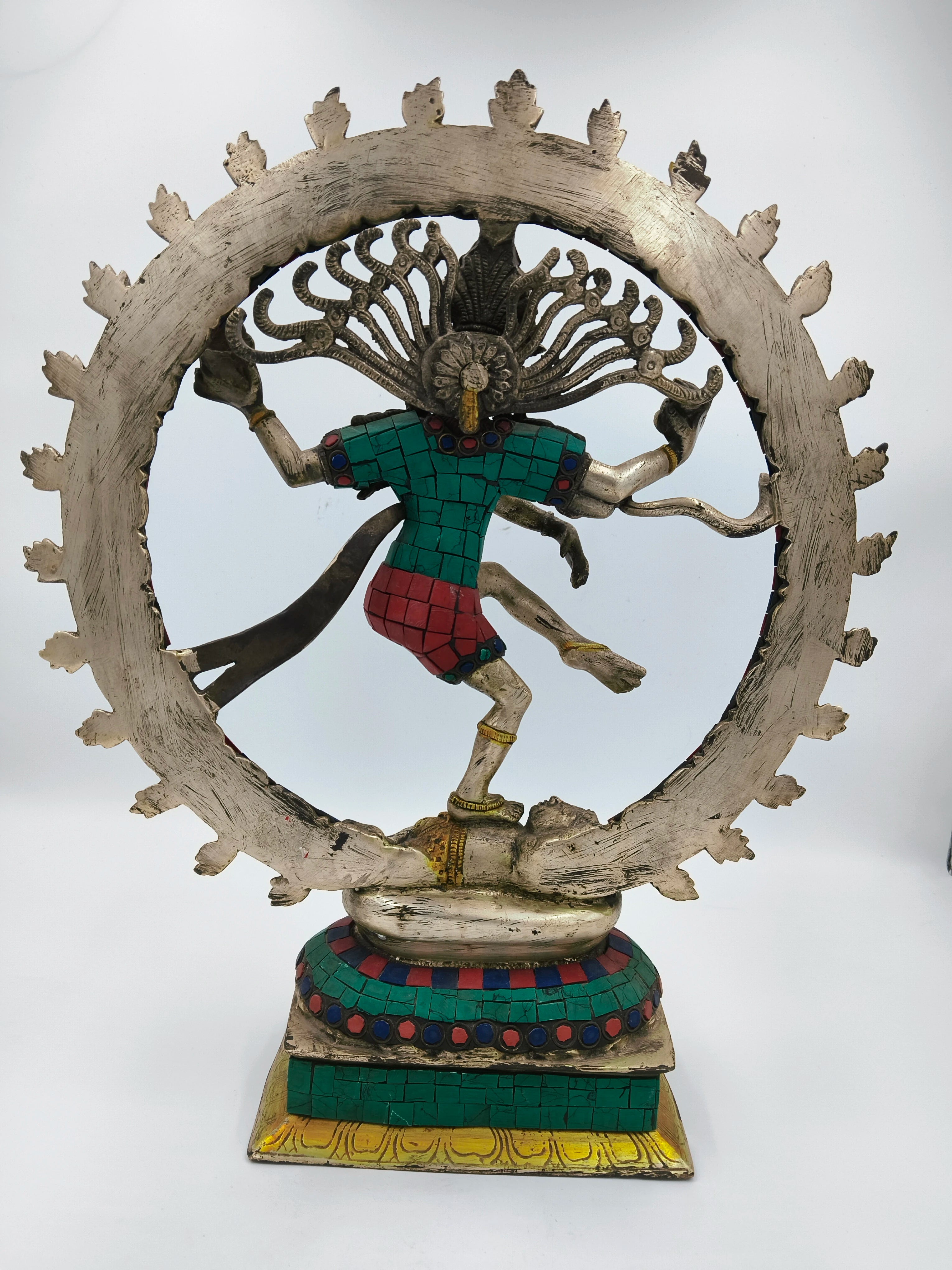 Back view of brass Nataraja sculpture with green and red inlay on decorated base