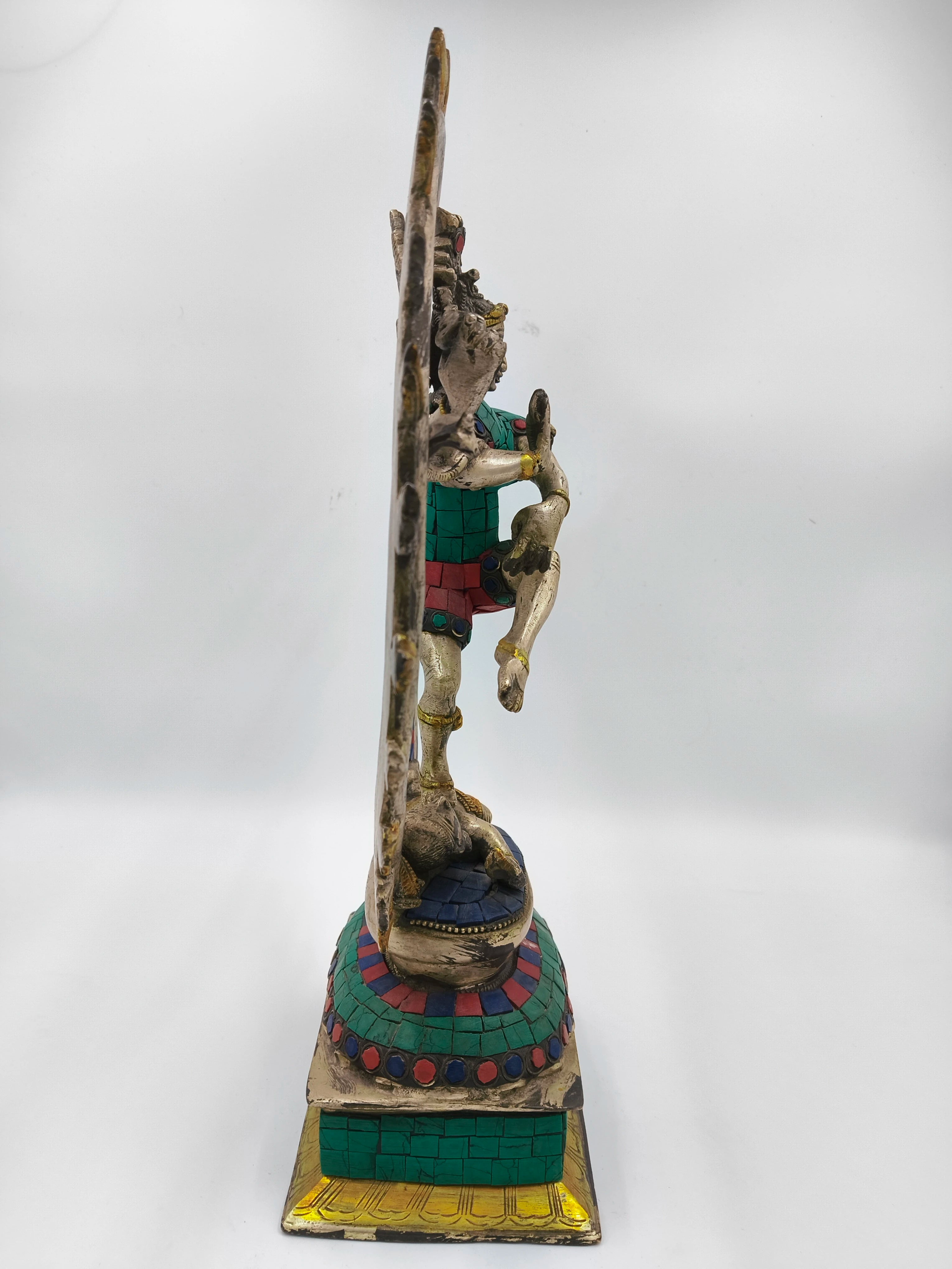 Side view of large brass Nataraja sculpture with colored inlay details