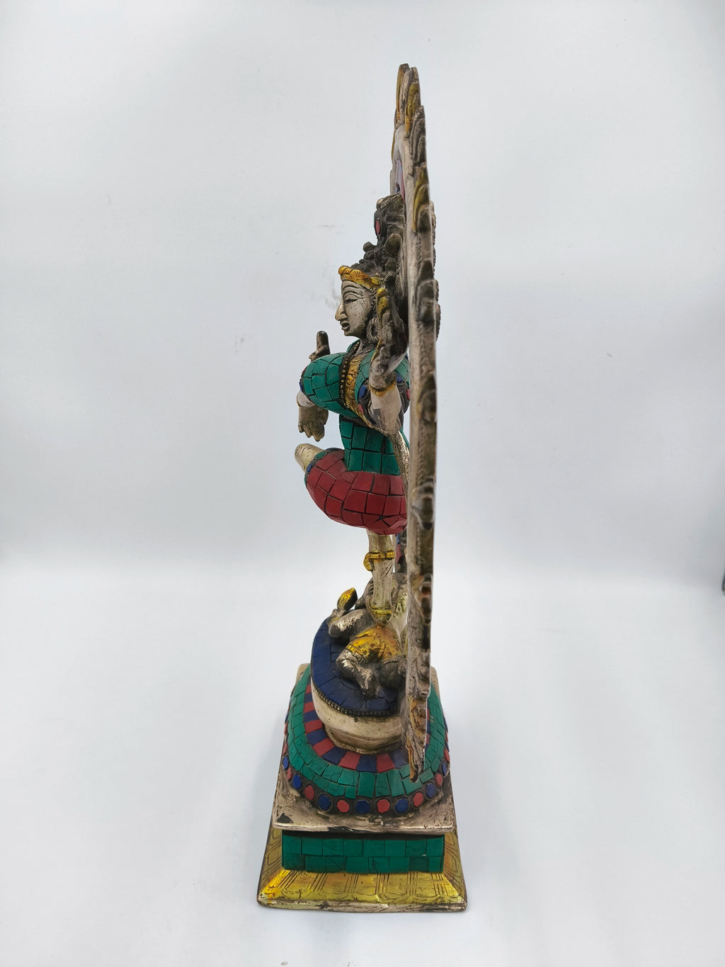 Side view of a colorful brass Nataraja sculpture with intricate detailing