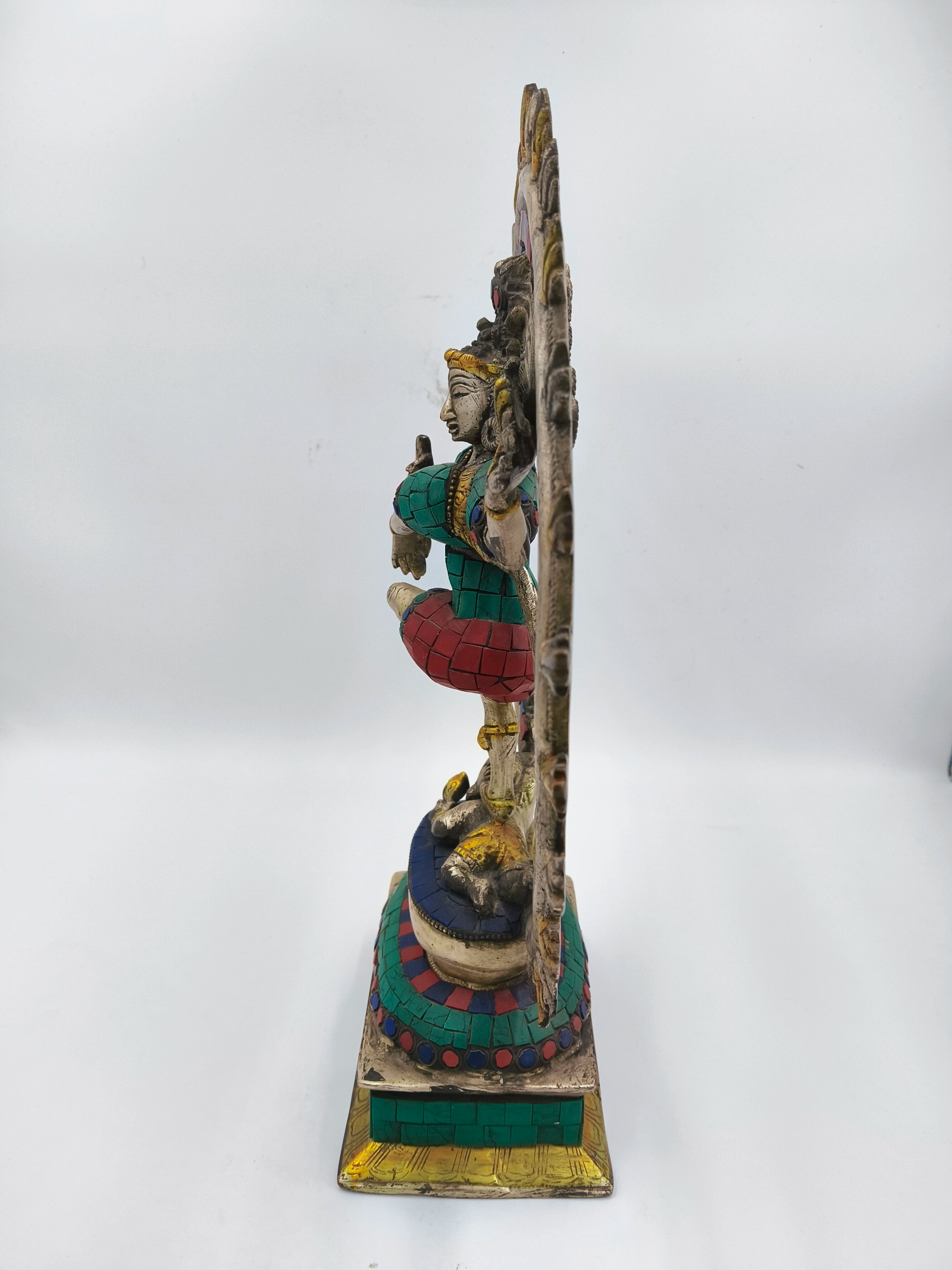 Side view of a colorful brass Nataraja sculpture with intricate detailing