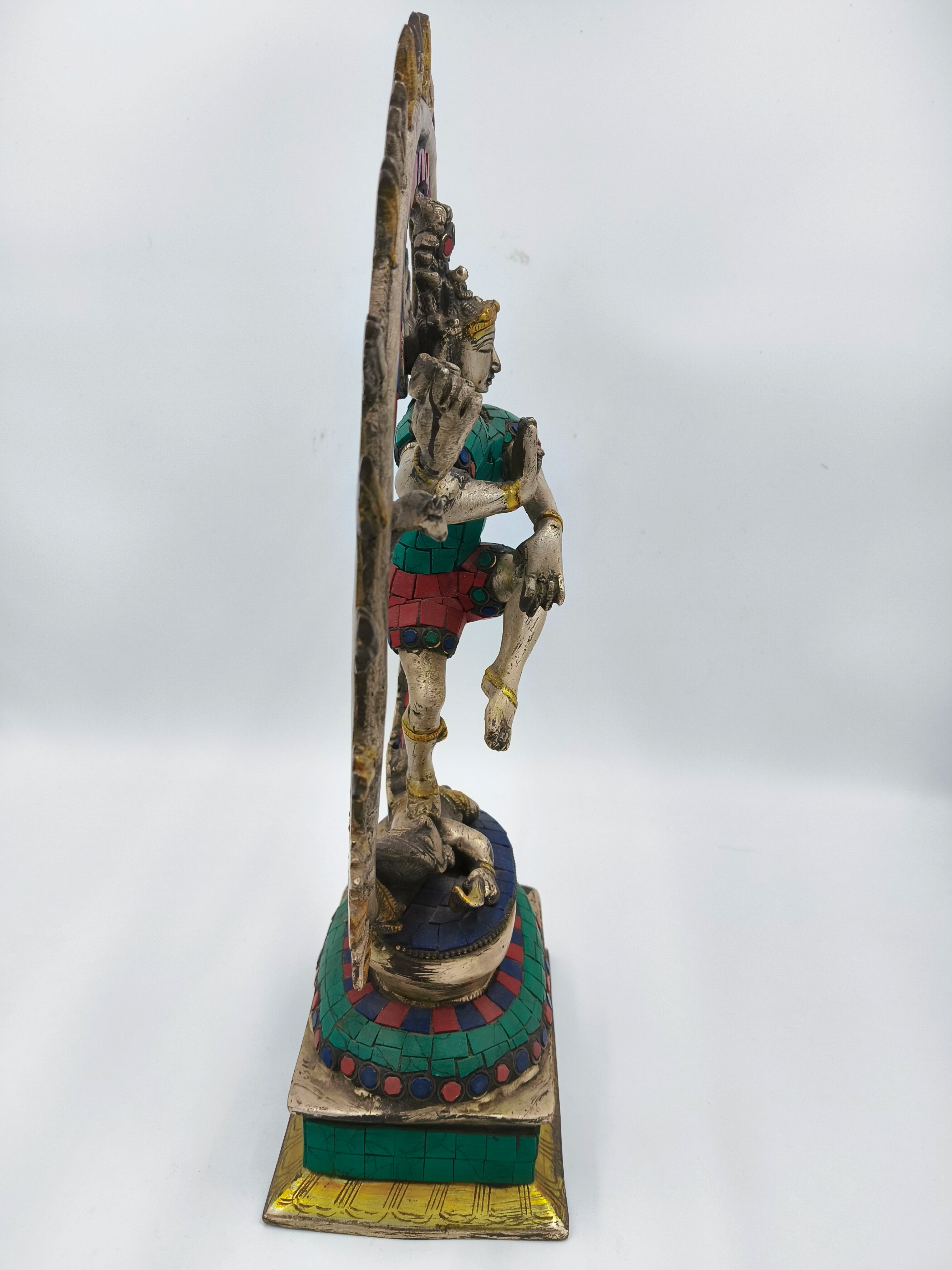 Side view of a colorful brass Nataraja sculpture with inlaid turquoise and red stones