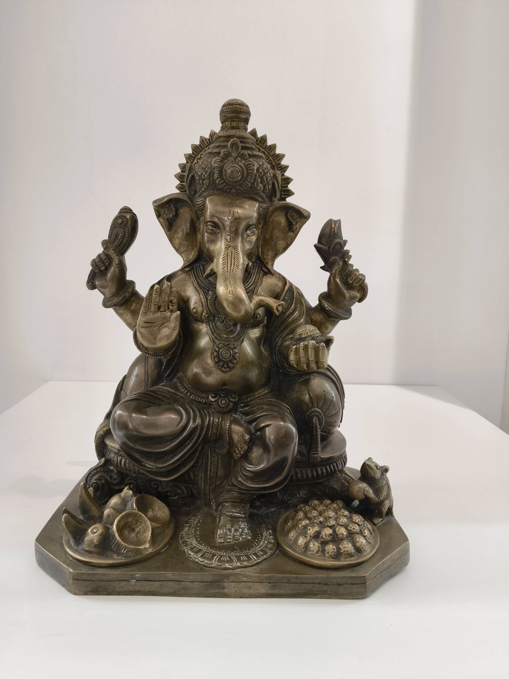 Large brass statue of Hindu deity Ganesh seated with detailed ornaments