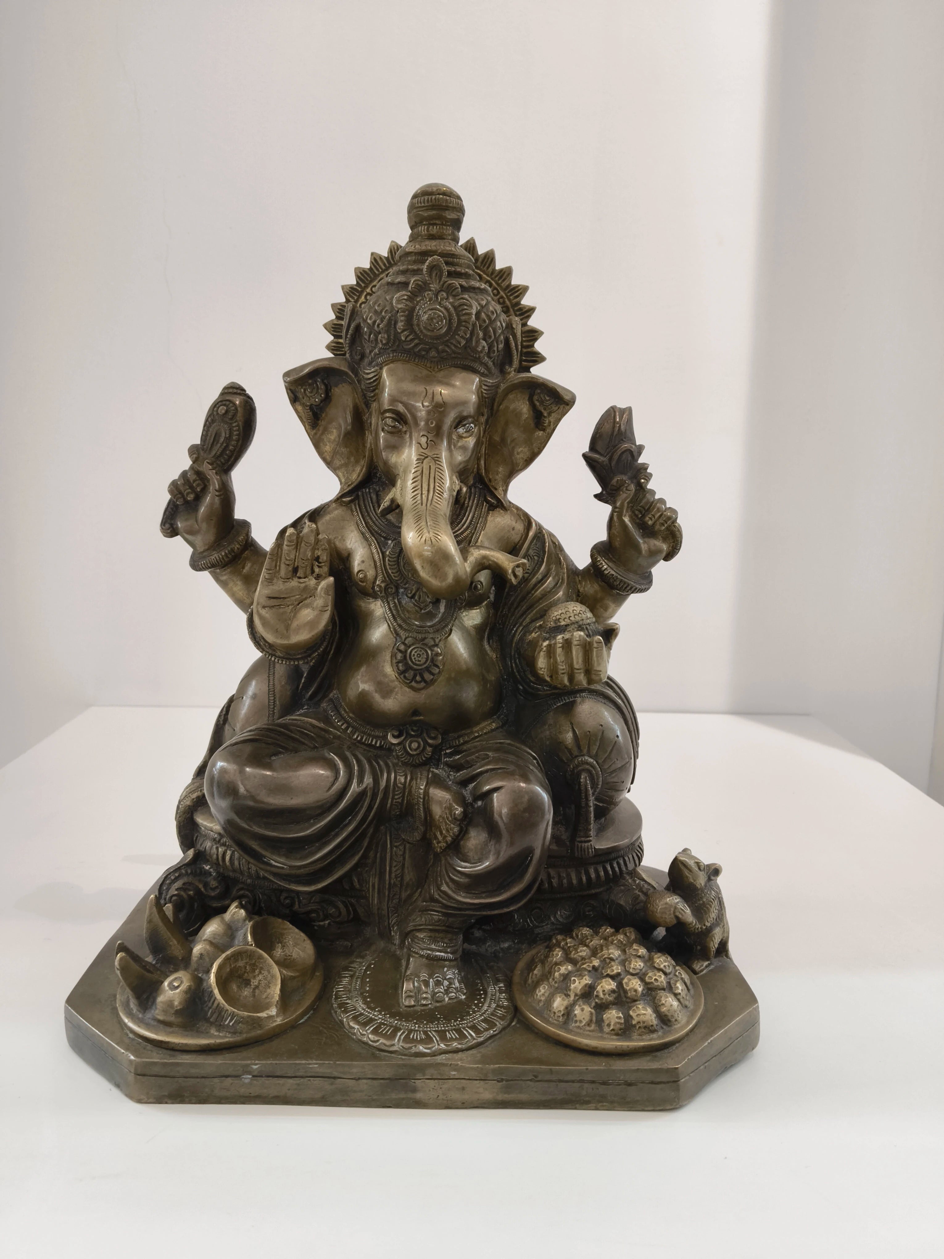 Large brass statue of Hindu deity Ganesh seated with detailed ornaments
