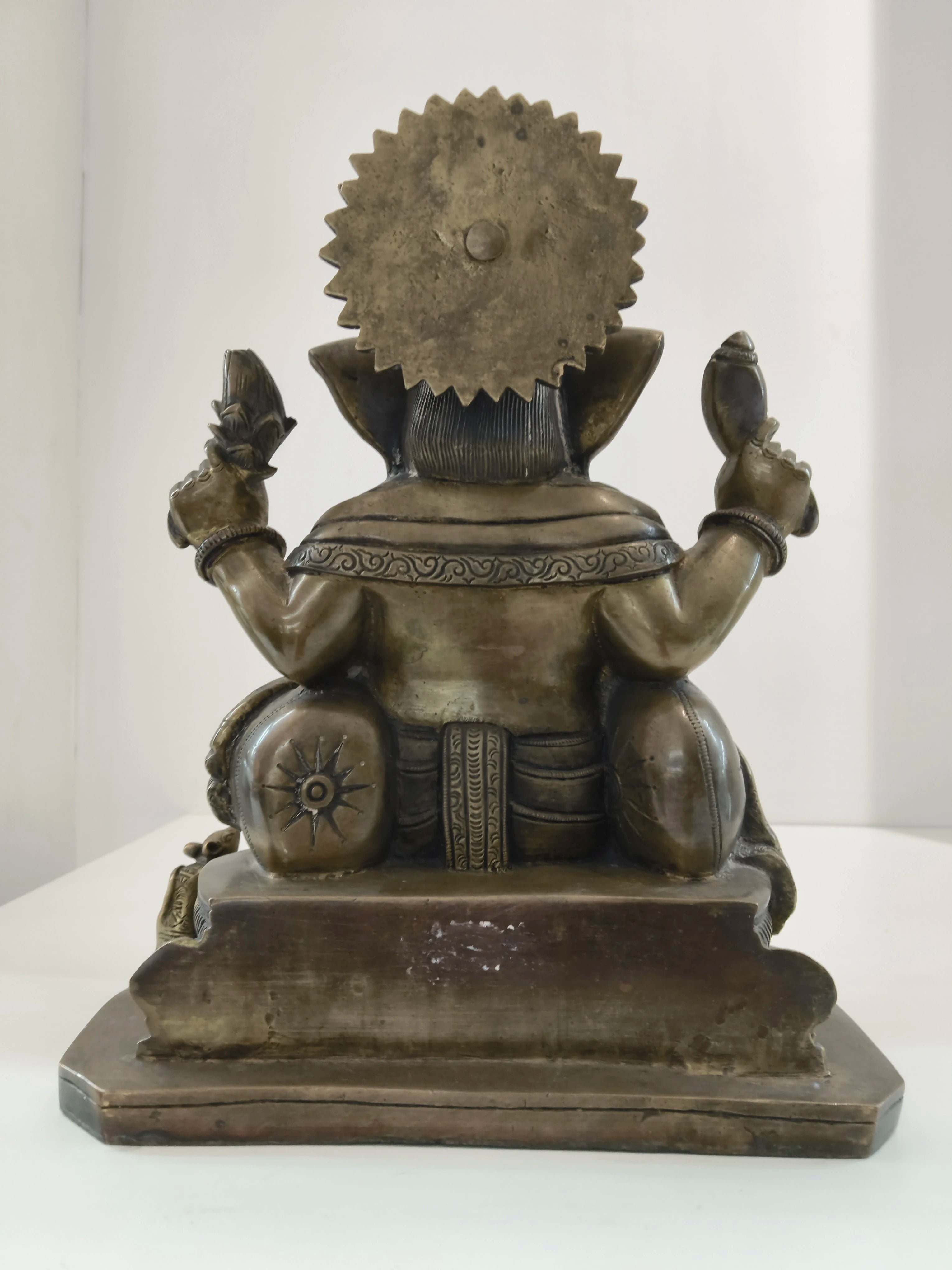 Back view of large brass Ganesh statue with detailed engravings