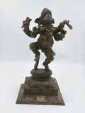 Large brass sculpture of dancing Ganesh on decorative base