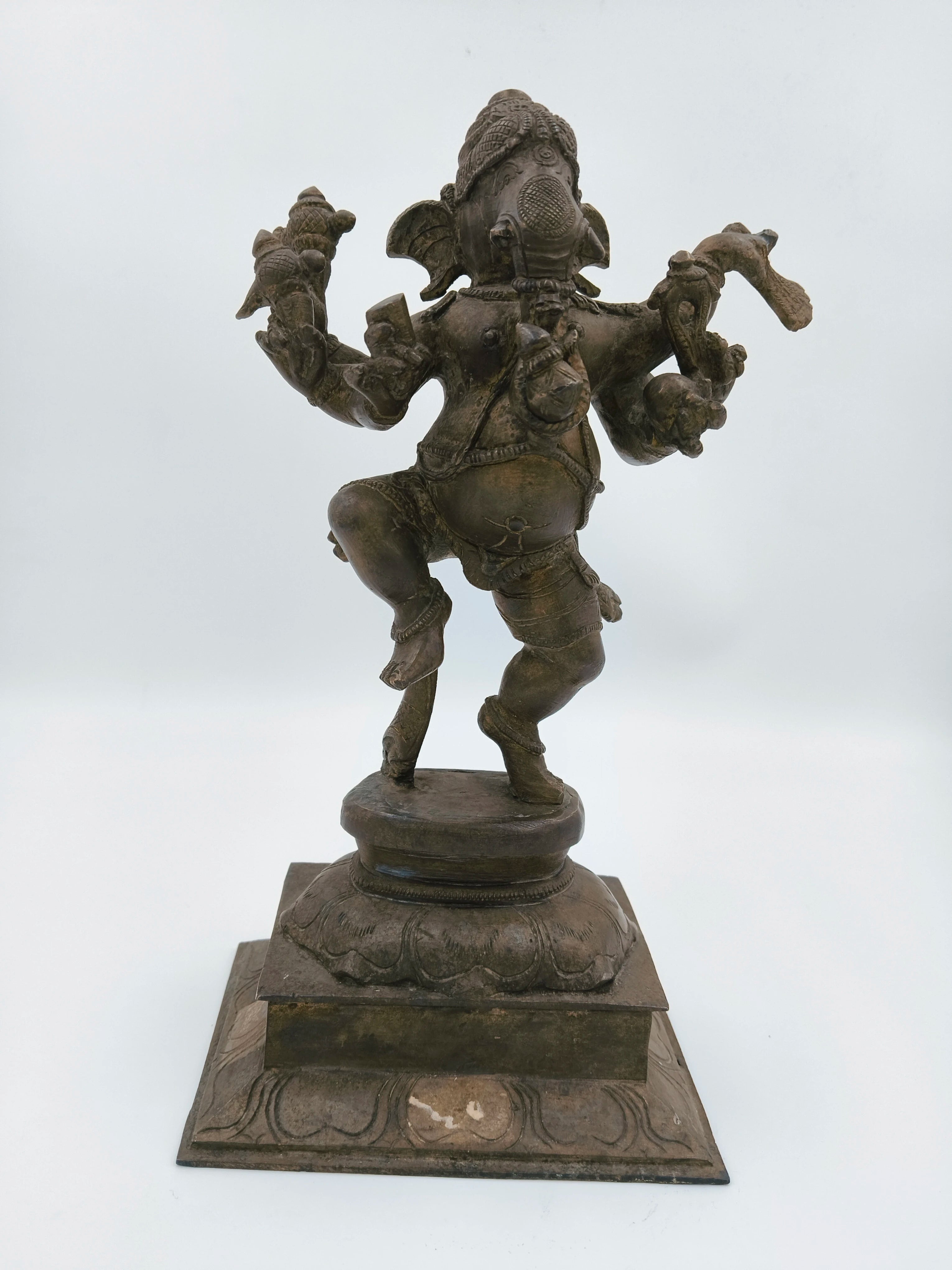 Large brass sculpture of dancing Ganesh on decorative base