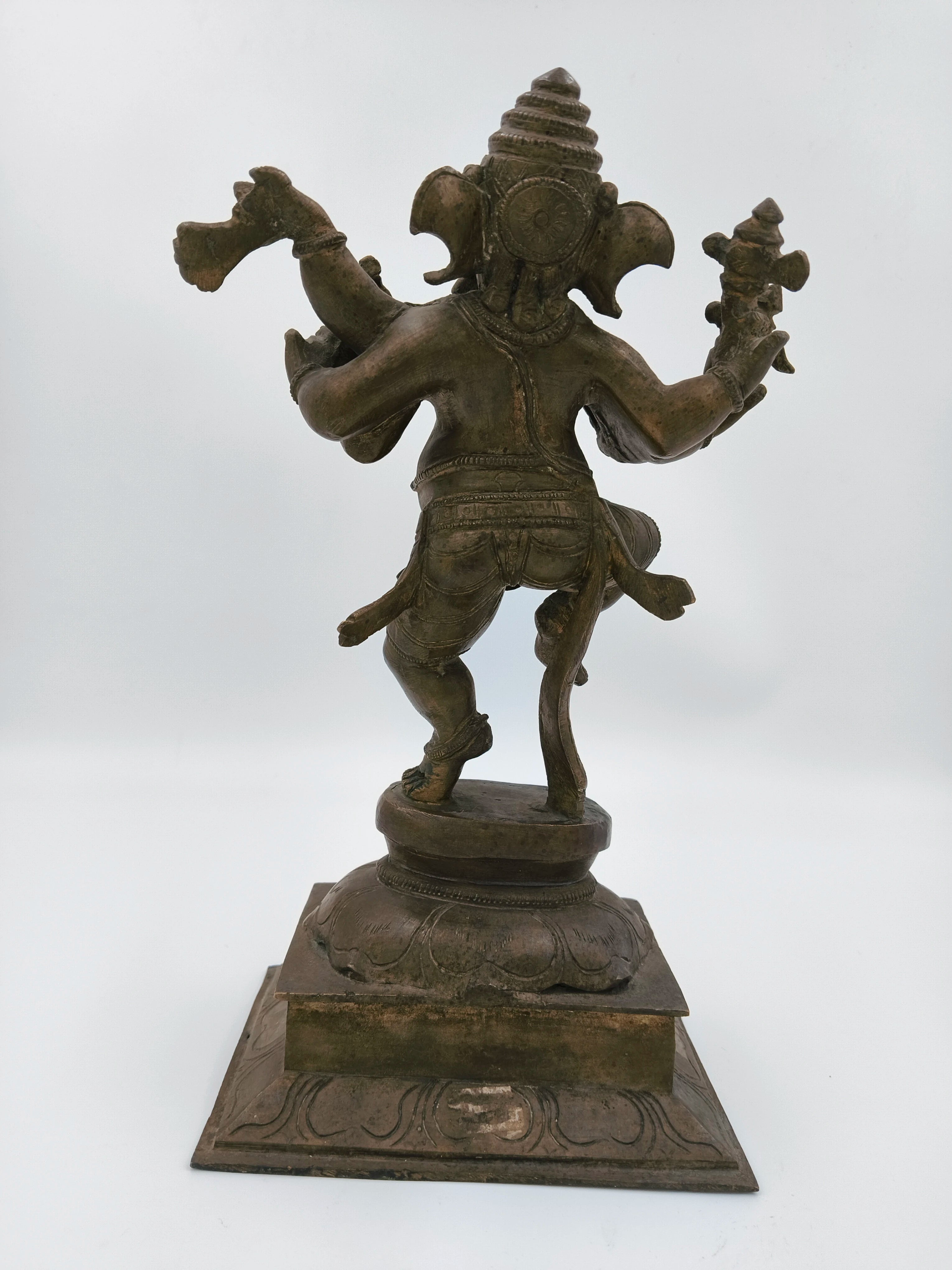 Back view of large brass bronze dancing Ganesh sculpture on decorative base