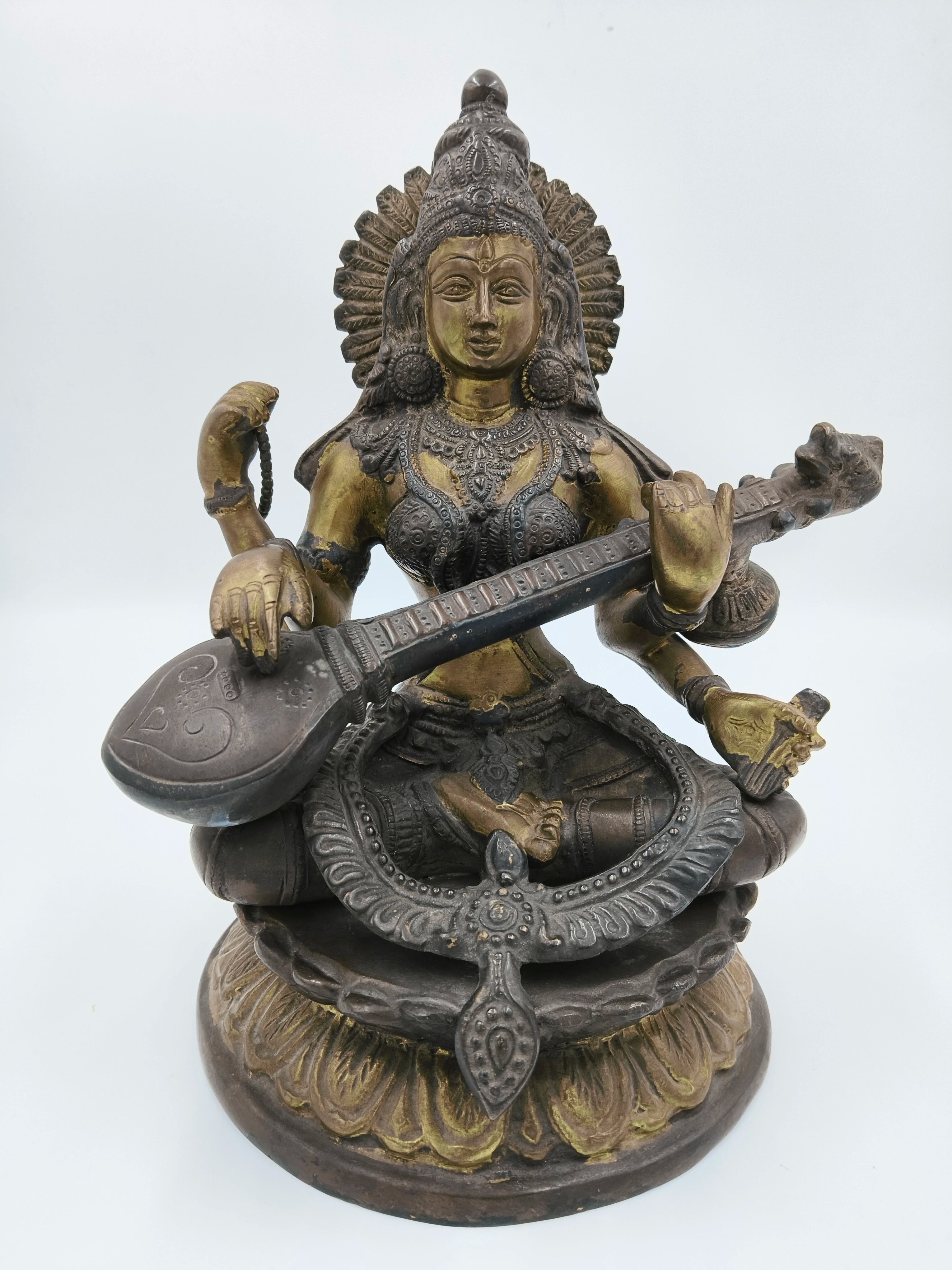 Brass 9-inch Saraswathi statue seated playing veena on decorative base