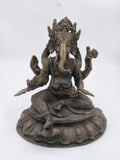 Brass statue of Ganesh seated on ornate base with detailed carvings
