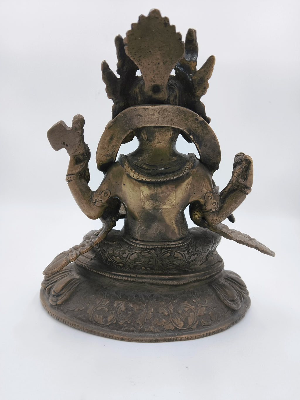 Back view of a brass Ganesh sculpture sitting on a detailed base