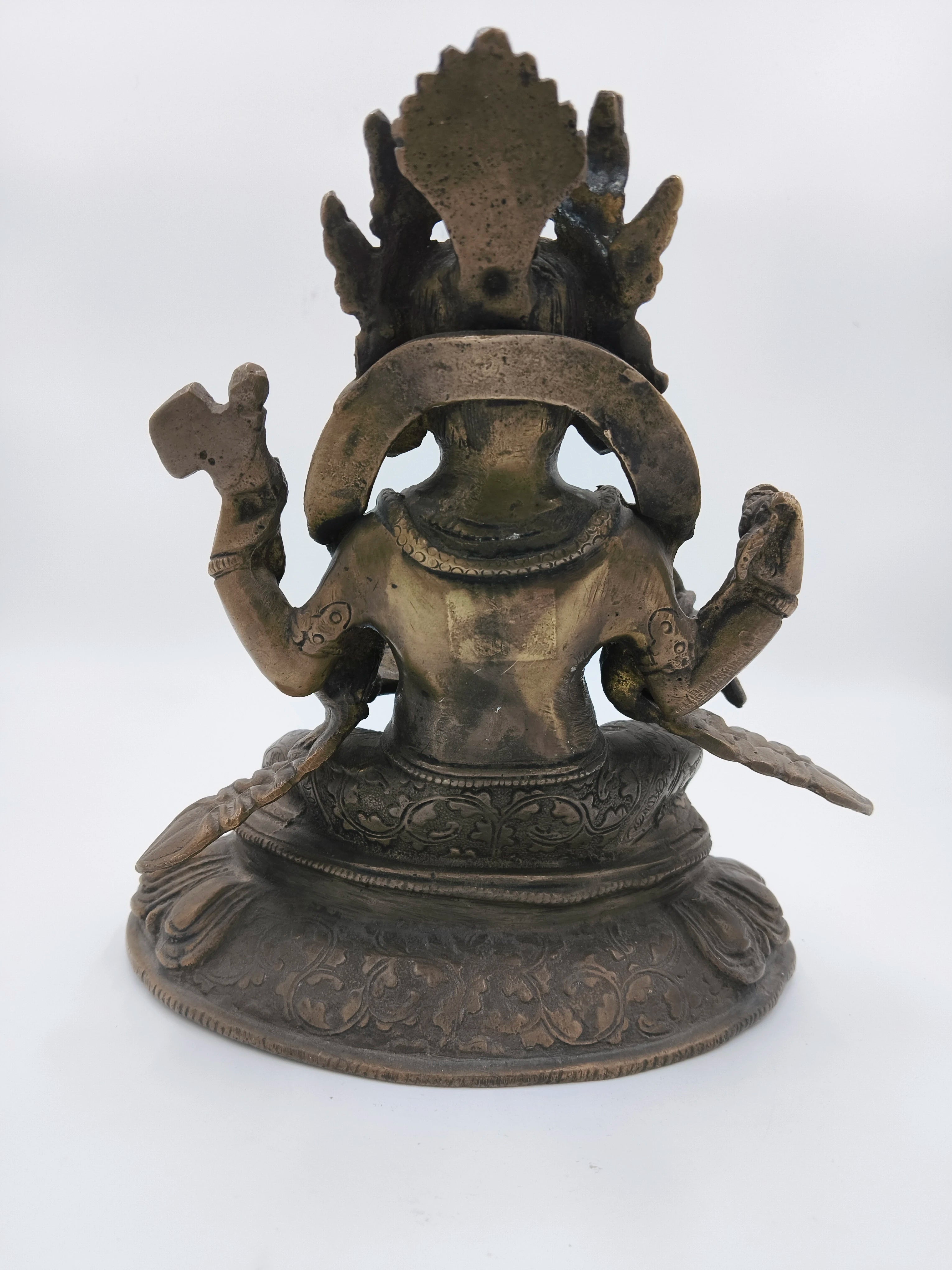 Back view of a brass Ganesh sculpture sitting on a detailed base