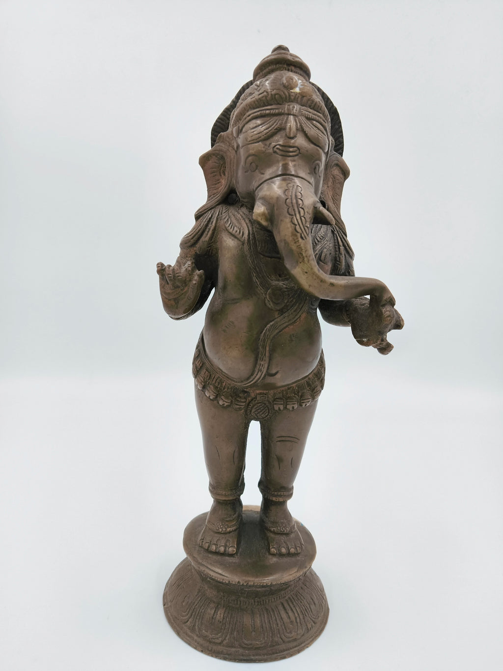 Large brass standing Ganesh sculpture with detailed carvings on pedestal