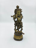 Large brass sculpture of Krishna playing flute with intricate detailing on pedestal
