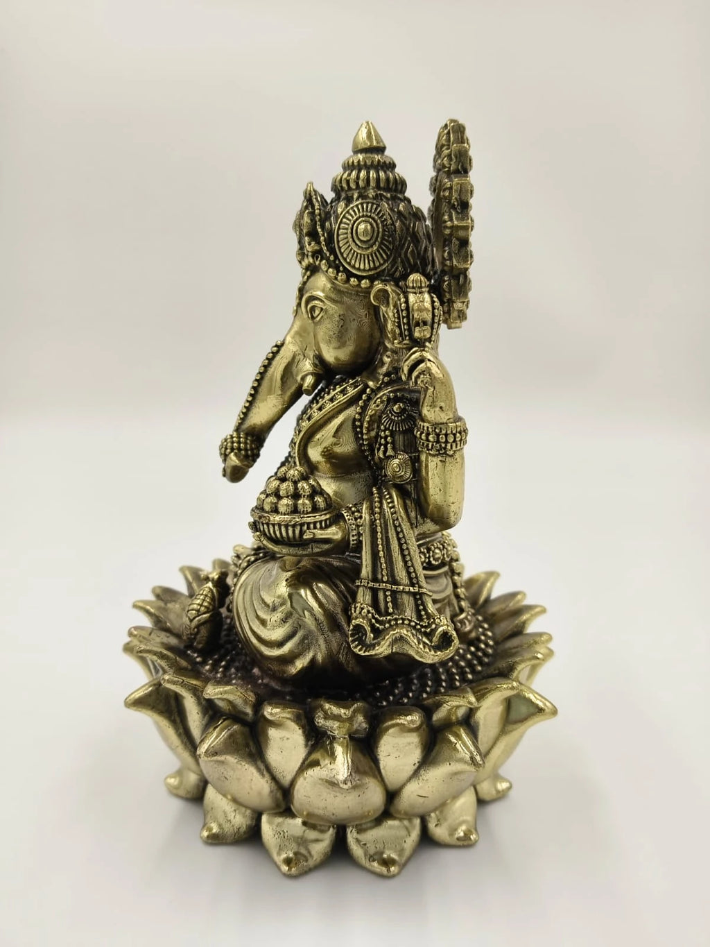 Brass sculpture of Padmasana Ganapati seated on a lotus pedestal, side view