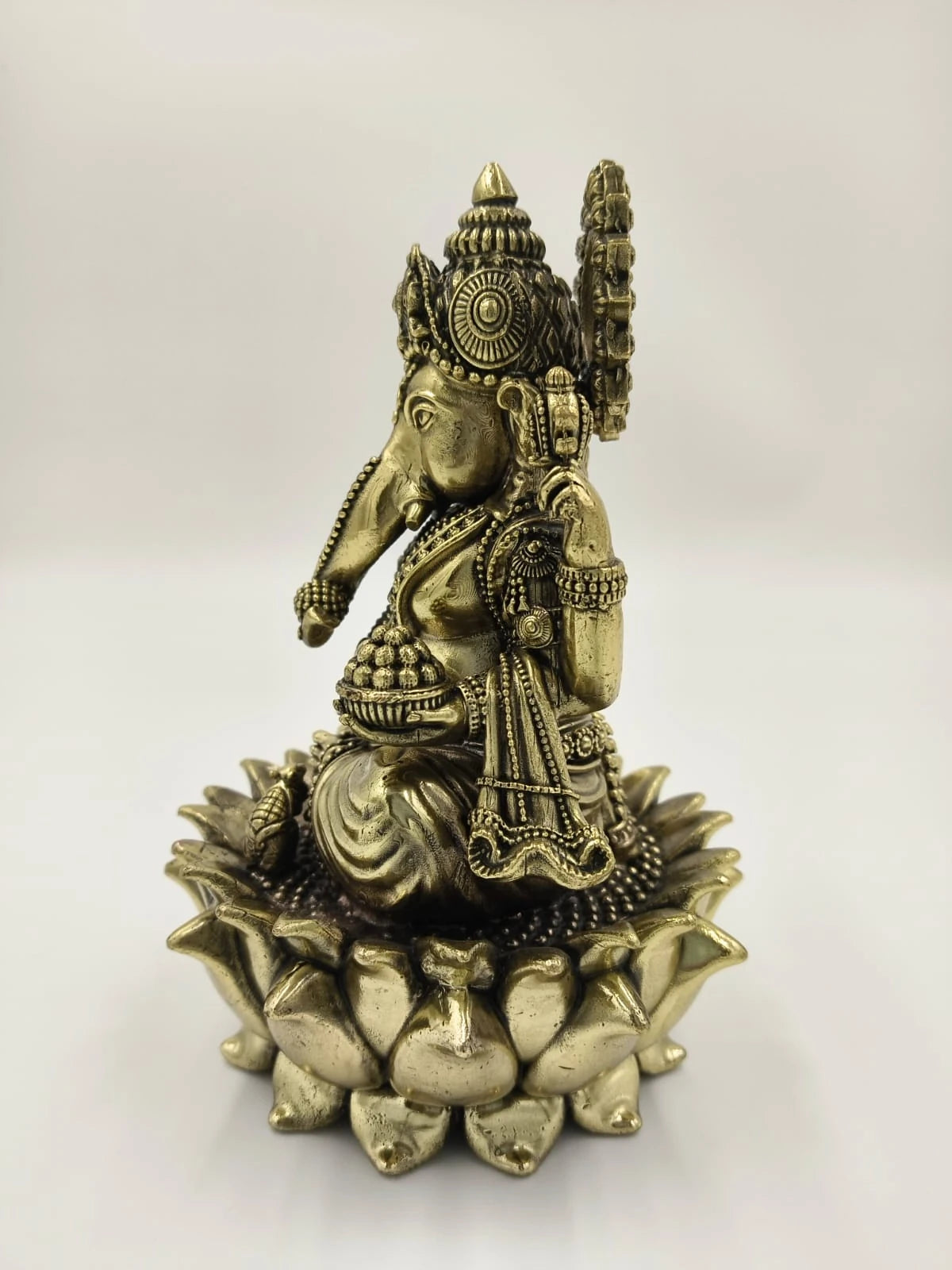 Brass sculpture of Padmasana Ganapati seated on a lotus pedestal, side view