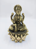 Brass statue of Dhanalakshmi seated on a lotus with four arms holding lotuses