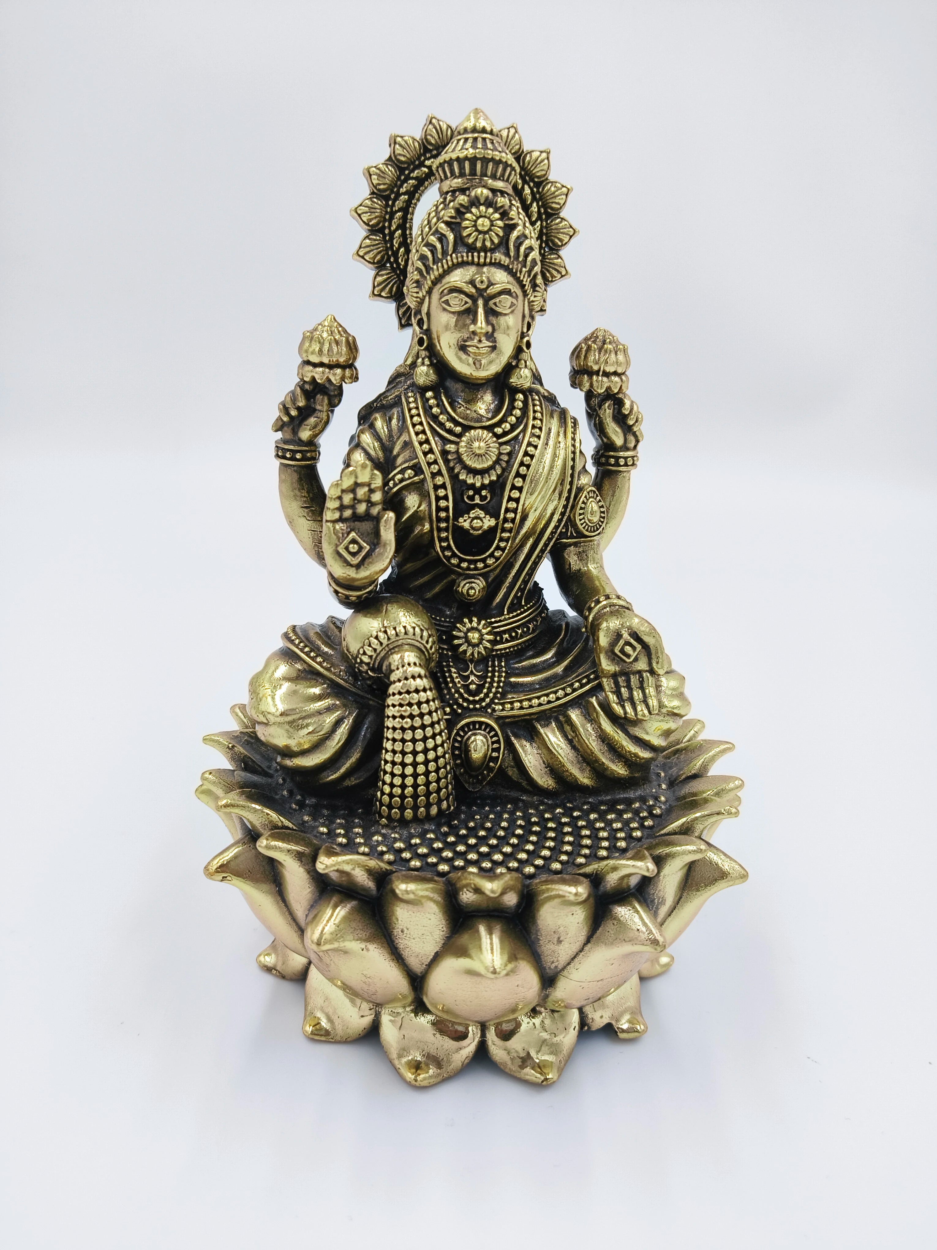 Brass statue of Dhanalakshmi seated on a lotus with four arms holding lotuses