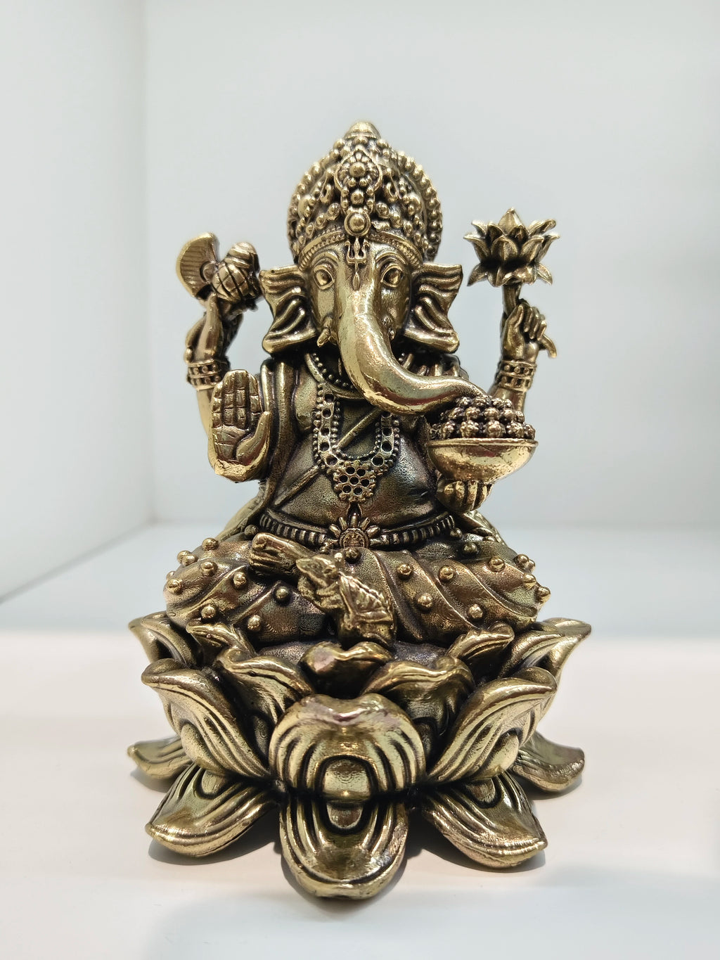 Mini brass Padmasana Ganapati statue sitting on a lotus base, front view