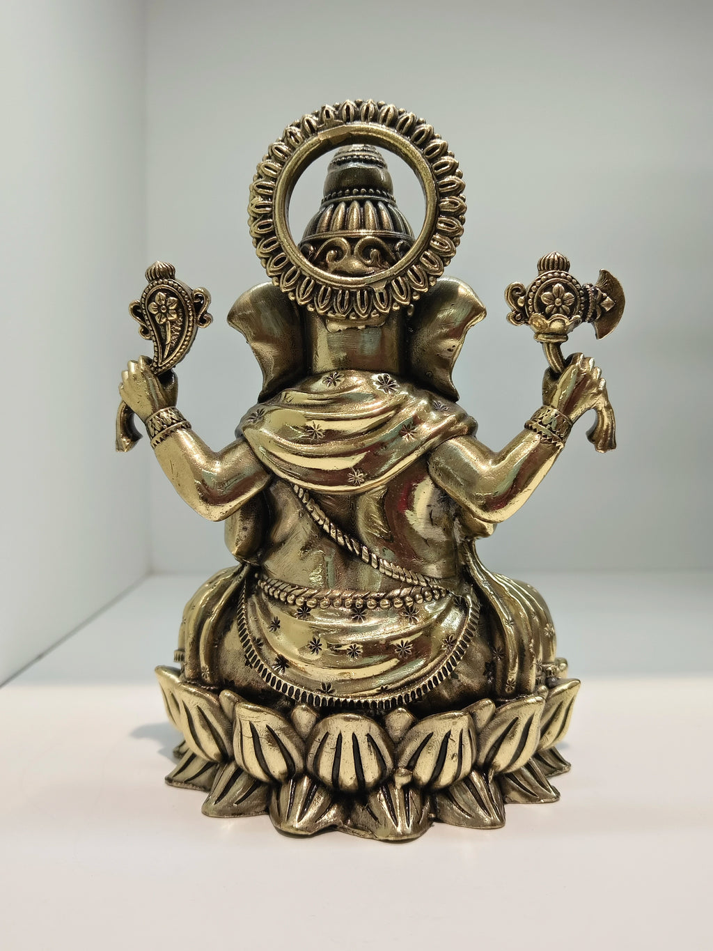 Back view of medium brass Ganesh statue seated in Padmasana lotus posture