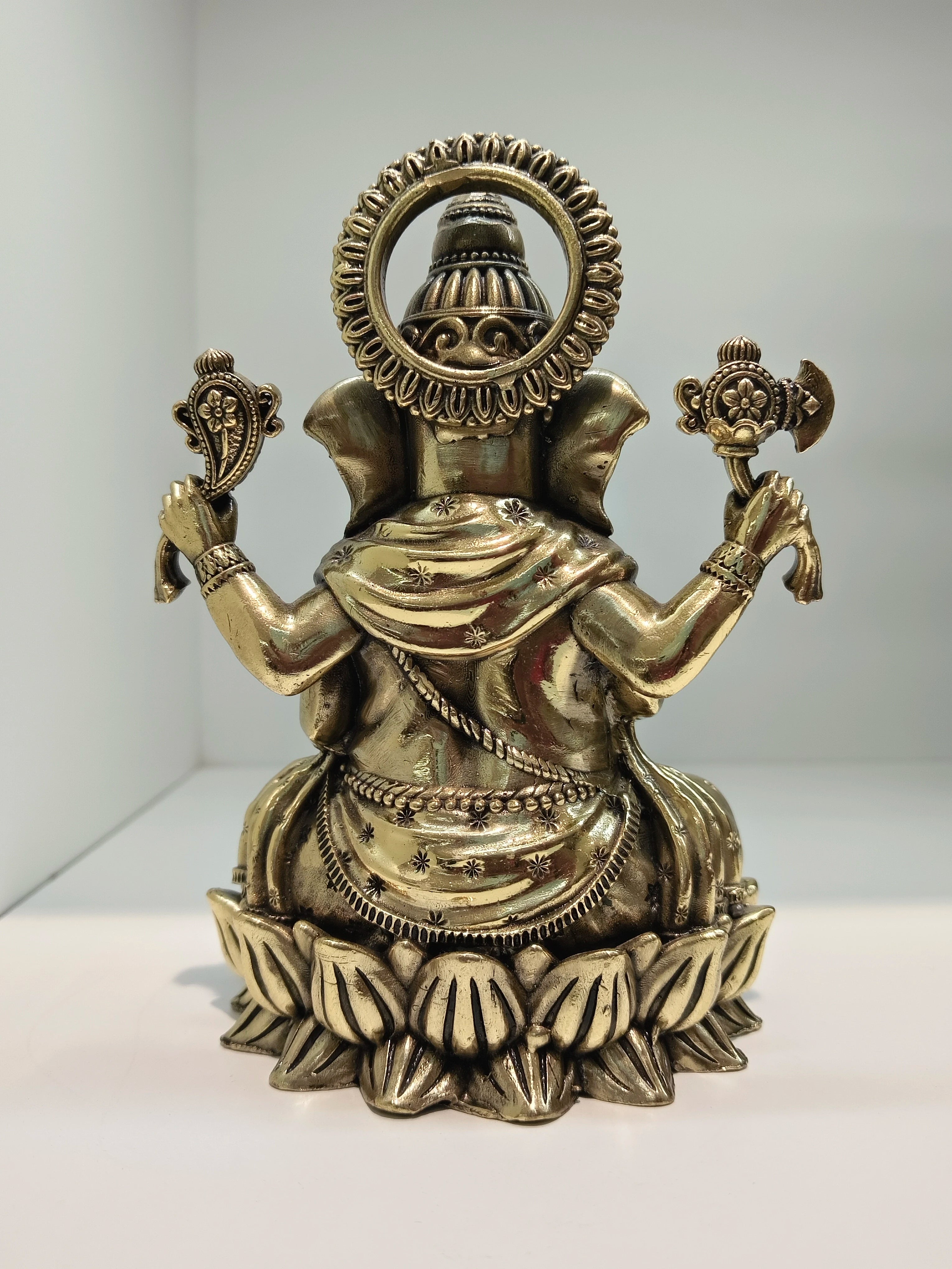 Back view of medium brass Ganesh statue seated in Padmasana lotus posture