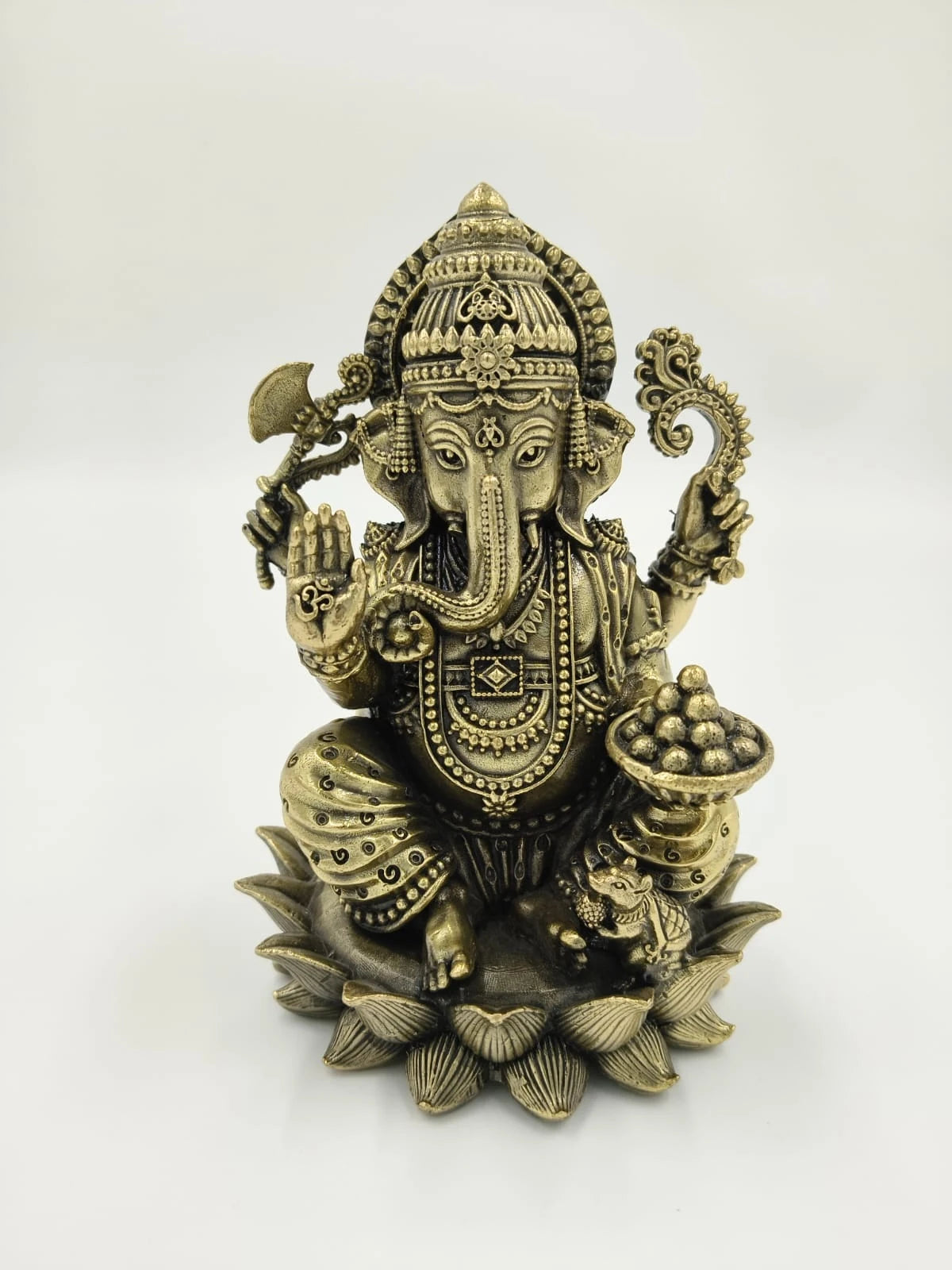 Medium brass sculpture of Ganesh sitting on a lotus with intricate details
