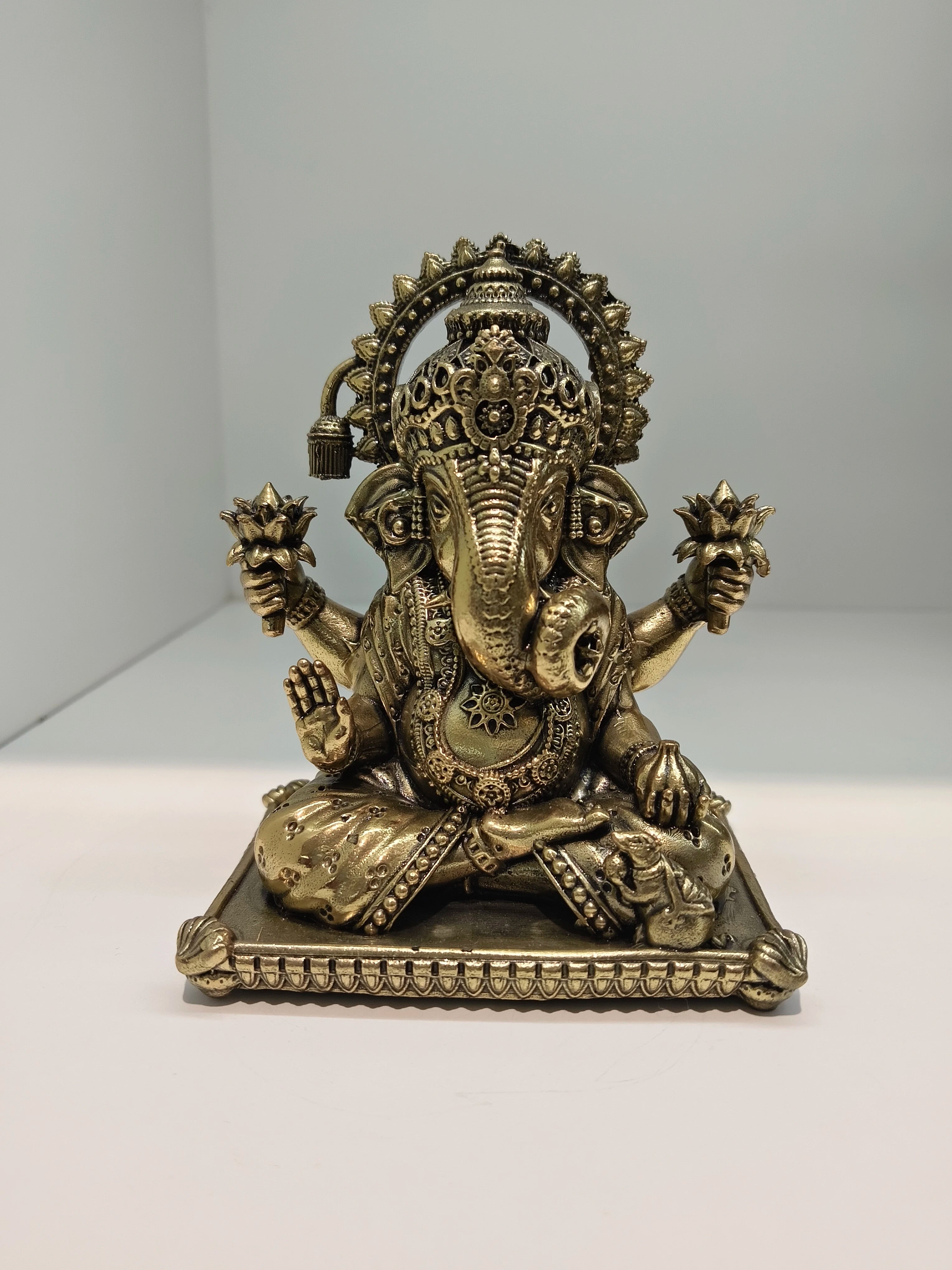 Small brass Padma Hasta Ganapati statue seated on decorative base