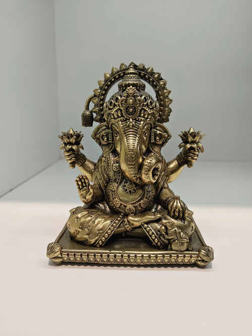 Small brass Padma Hasta Ganapati statue seated on decorative base