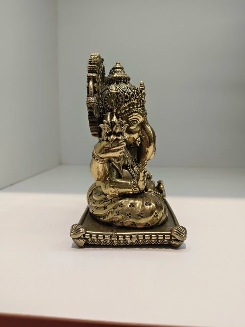 Small brass Padma Hasta Ganapati statue side view on ornate base