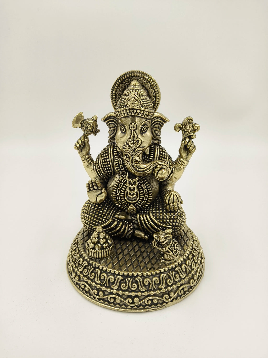 Brass Padma Hasta Ganapati statue with intricate detailing seated on decorative base