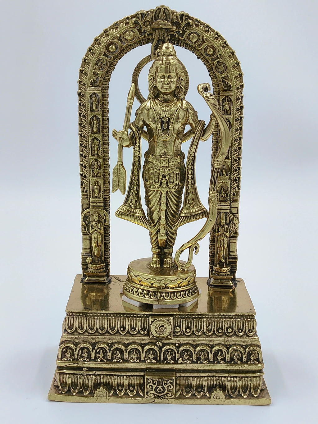 Brass sculpture of Ayodhya Rama standing on ornate pedestal with arch backdrop