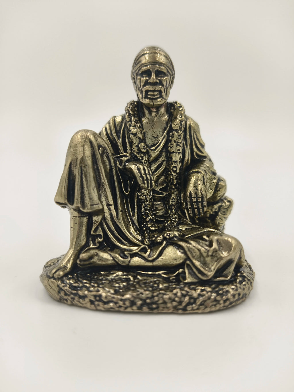 Mini brass sculpture of Shirdi Sai Baba seated with garlands