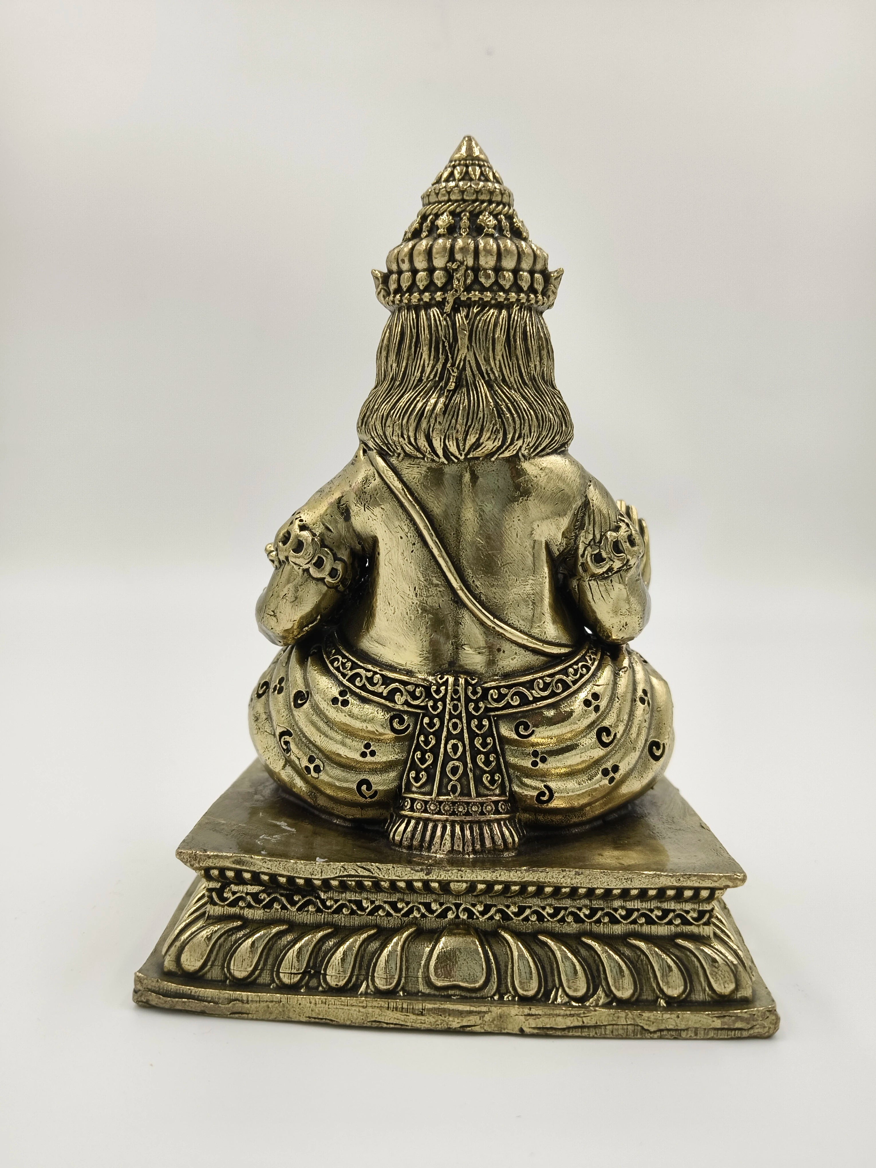 Back view of medium brass Kubera statue sitting on decorative base