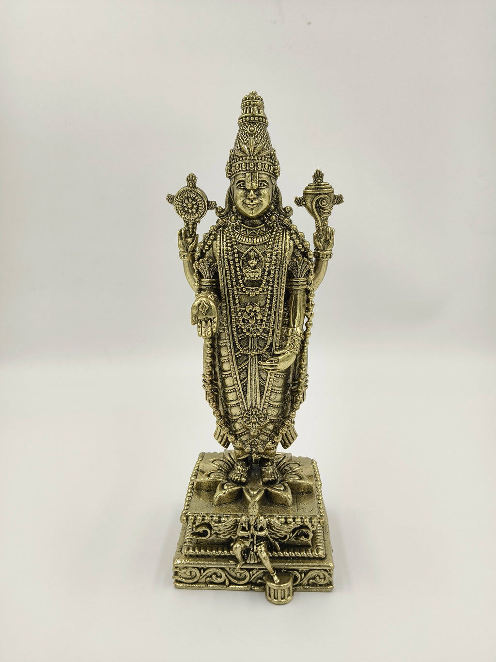 Front view of a detailed brass Balaji statue standing on a decorated base