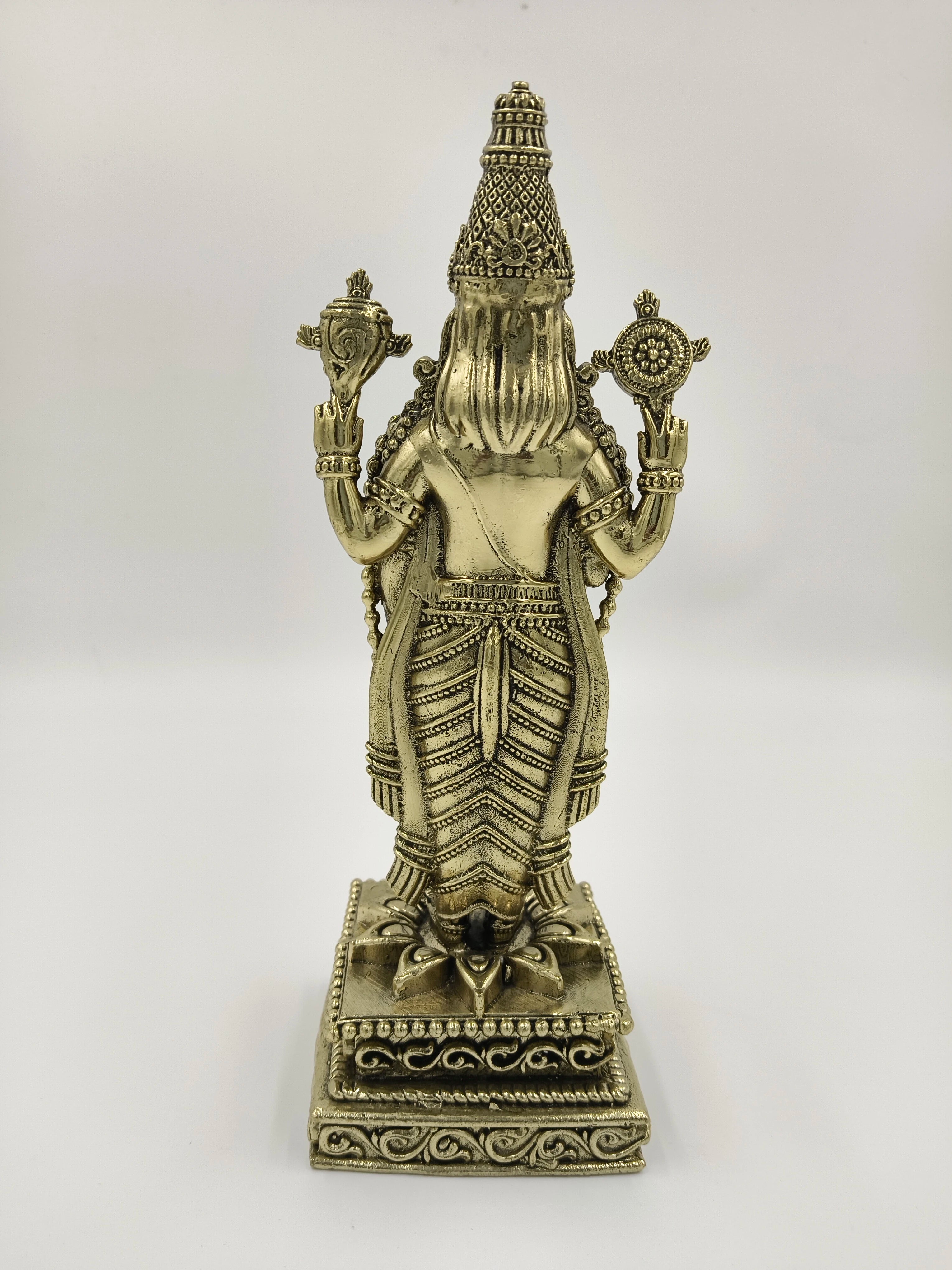 Back view of brass Balaji statue with intricate detailing and decorated base
