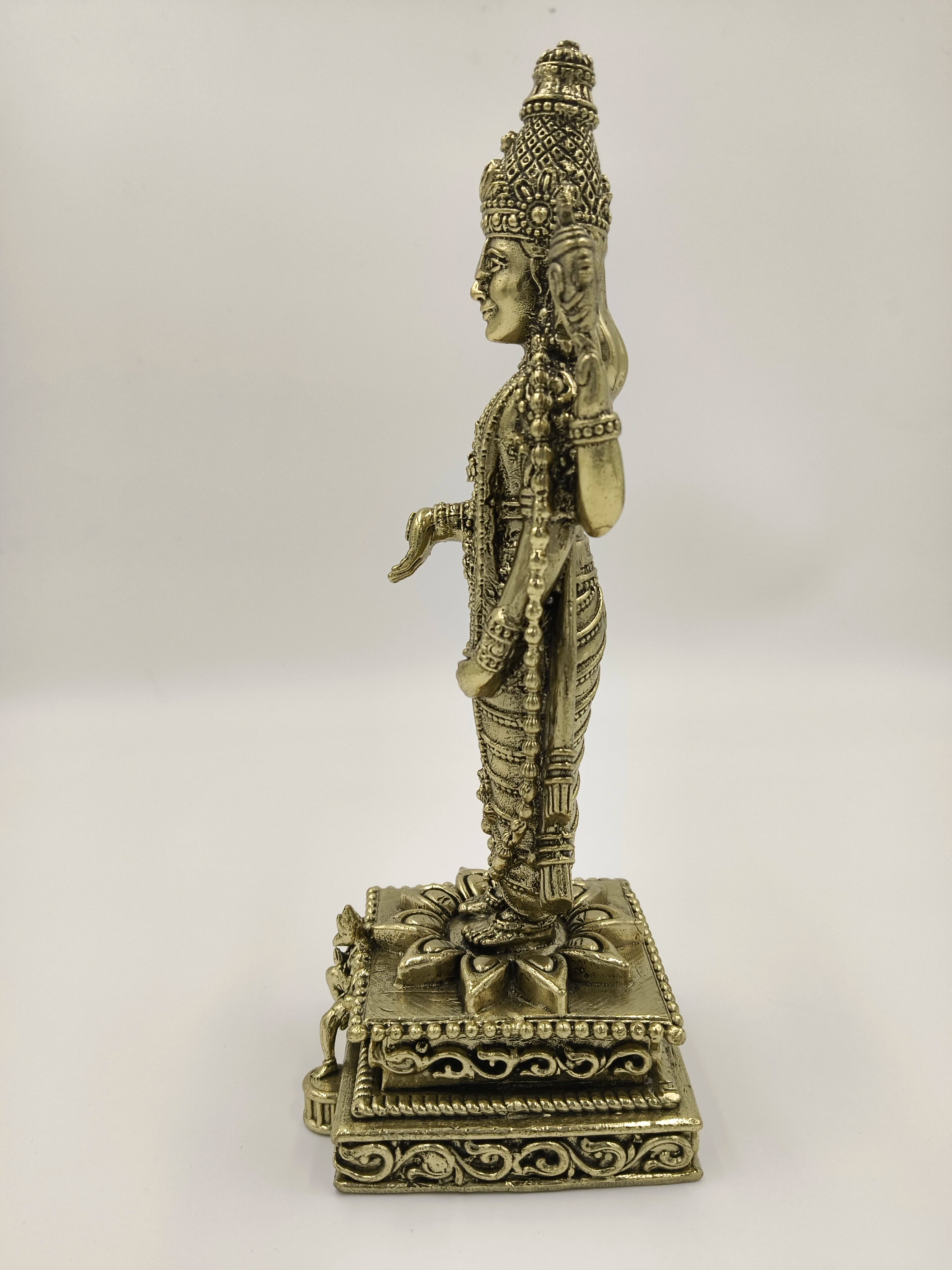 Side view of large brass Balaji sculpture with detailed carvings on base