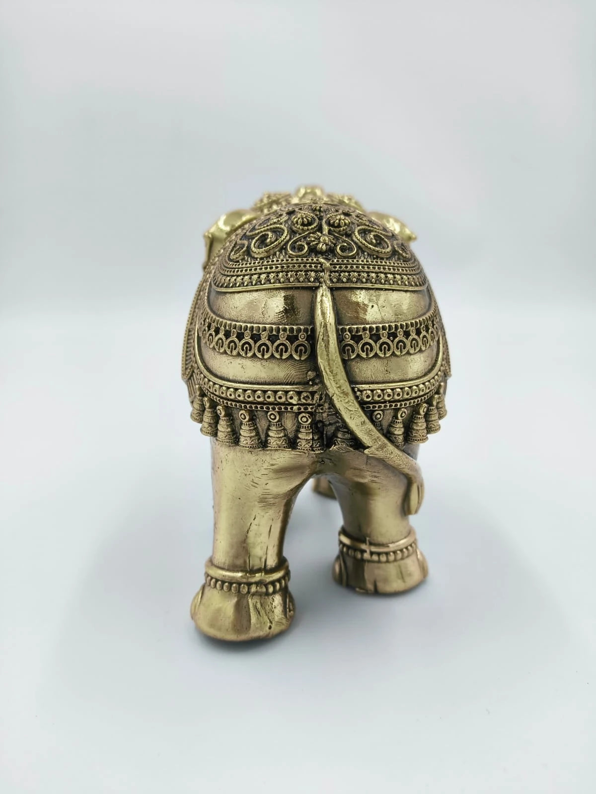 Back view of small brass elephant figurine with detailed ornamentation