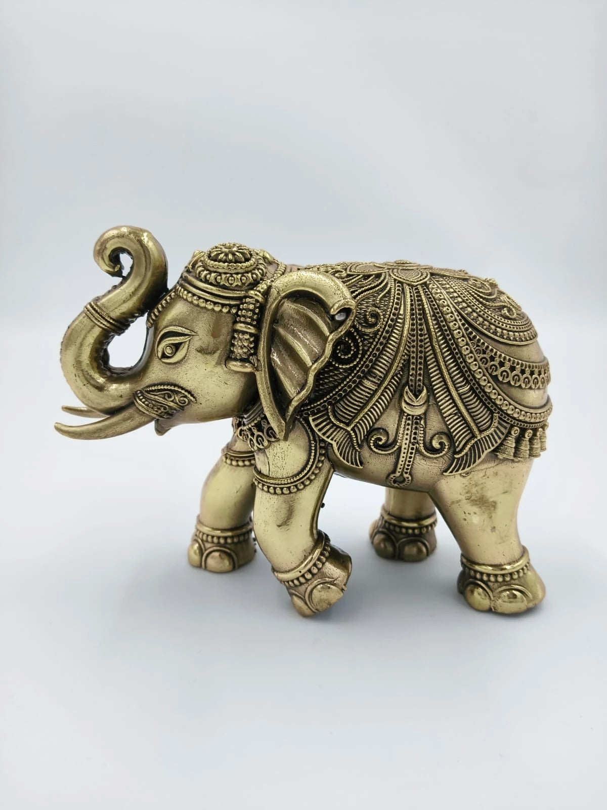 Brass elephant figurine with decorative engravings, side view