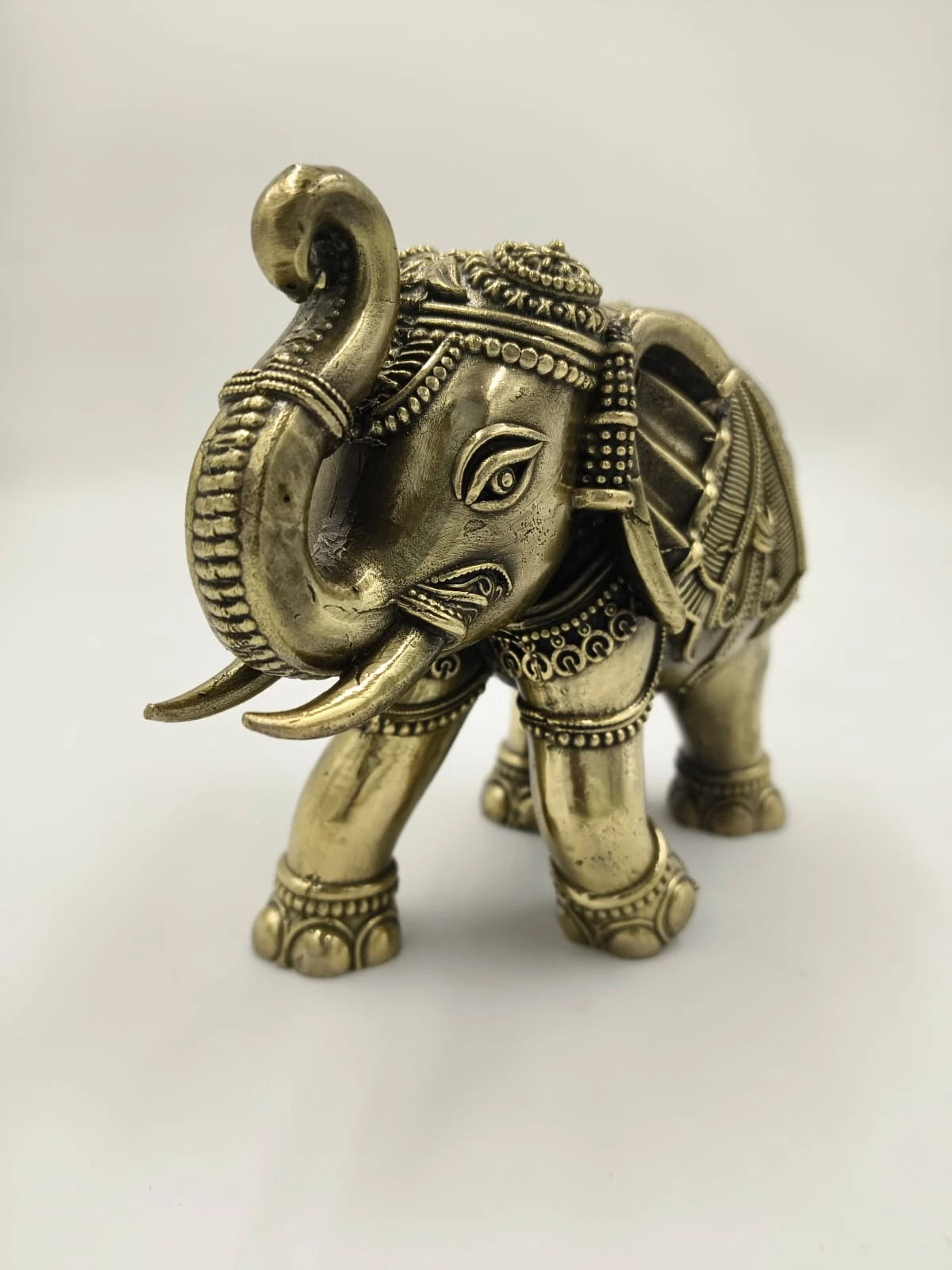 Small brass elephant sculpture with intricate decorative patterns