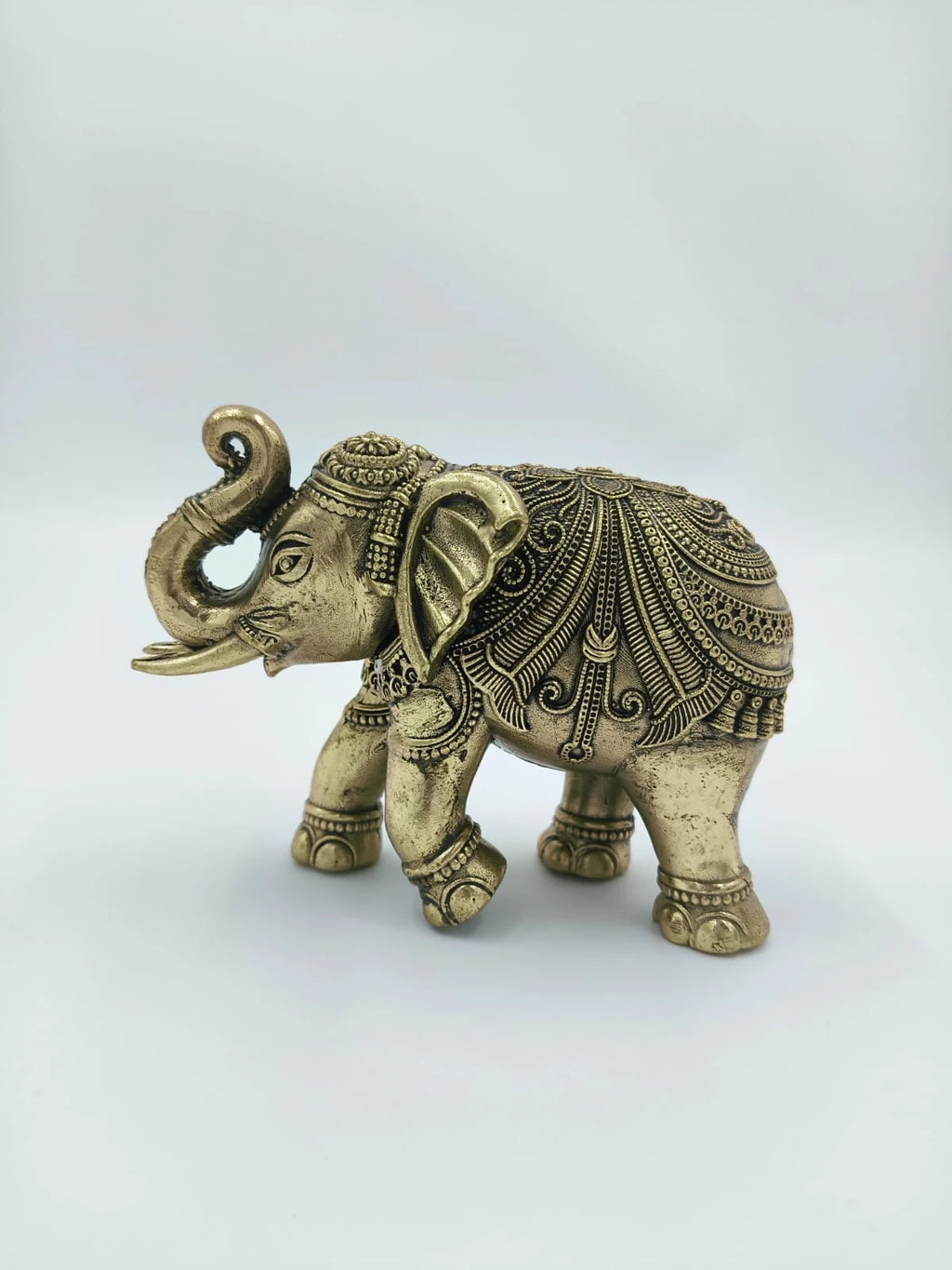 Small brass elephant sculpture with intricate ornamental detailing side view