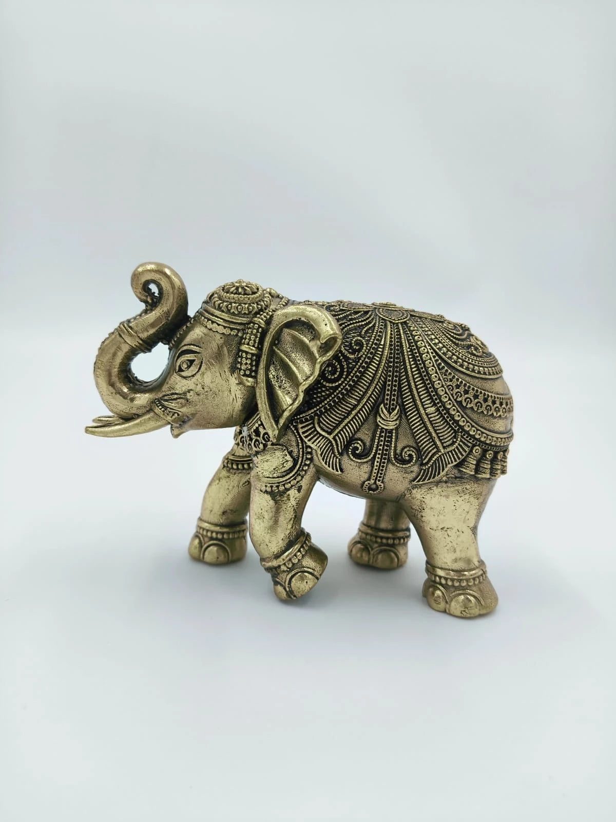 Small brass elephant sculpture with intricate ornamental detailing side view