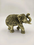 Small brass elephant figurine with intricate detailed engravings side view