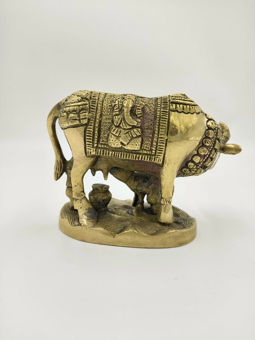 Brass sculpture of a cow and calf with carved Ganesha motif on blanket