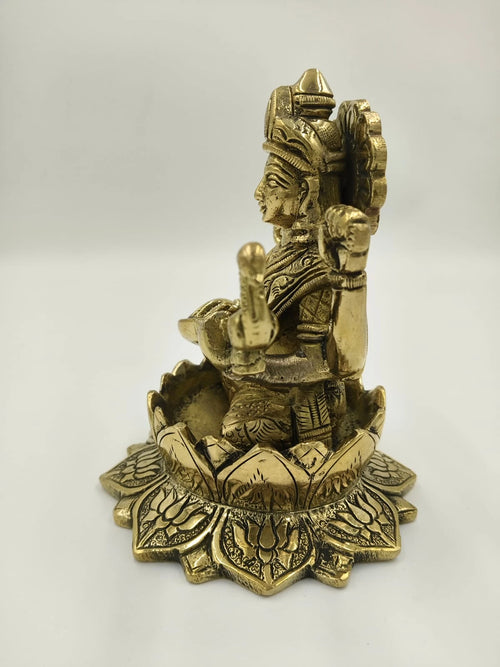 Side view of brass Saraswathi statue seated on lotus pedestal