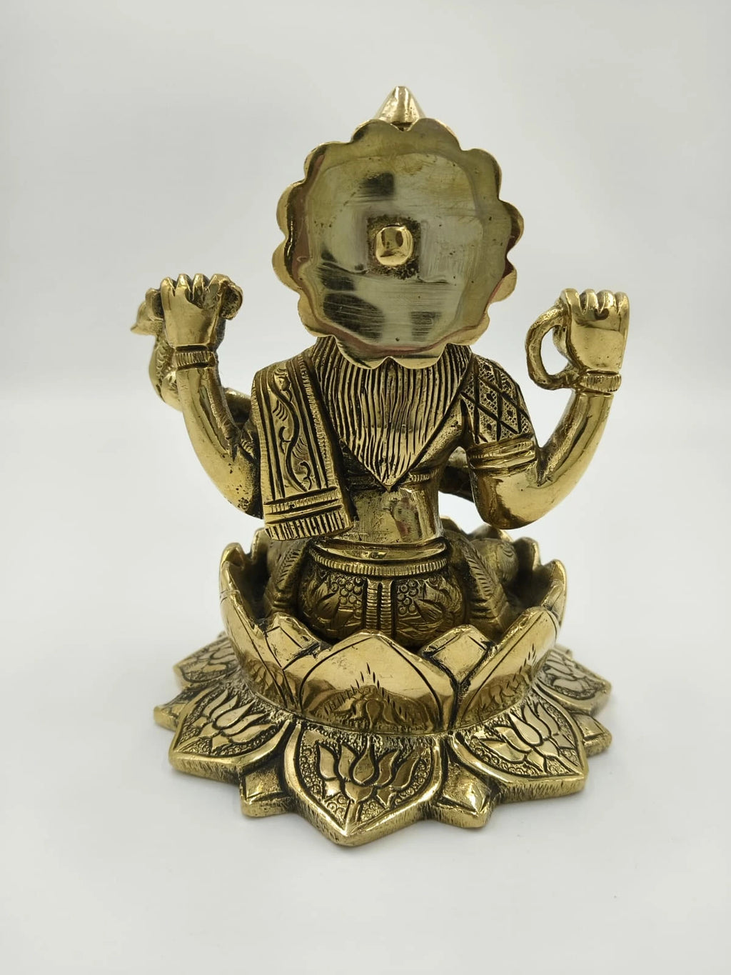Back view of brass Saraswathi statue sitting on detailed lotus base
