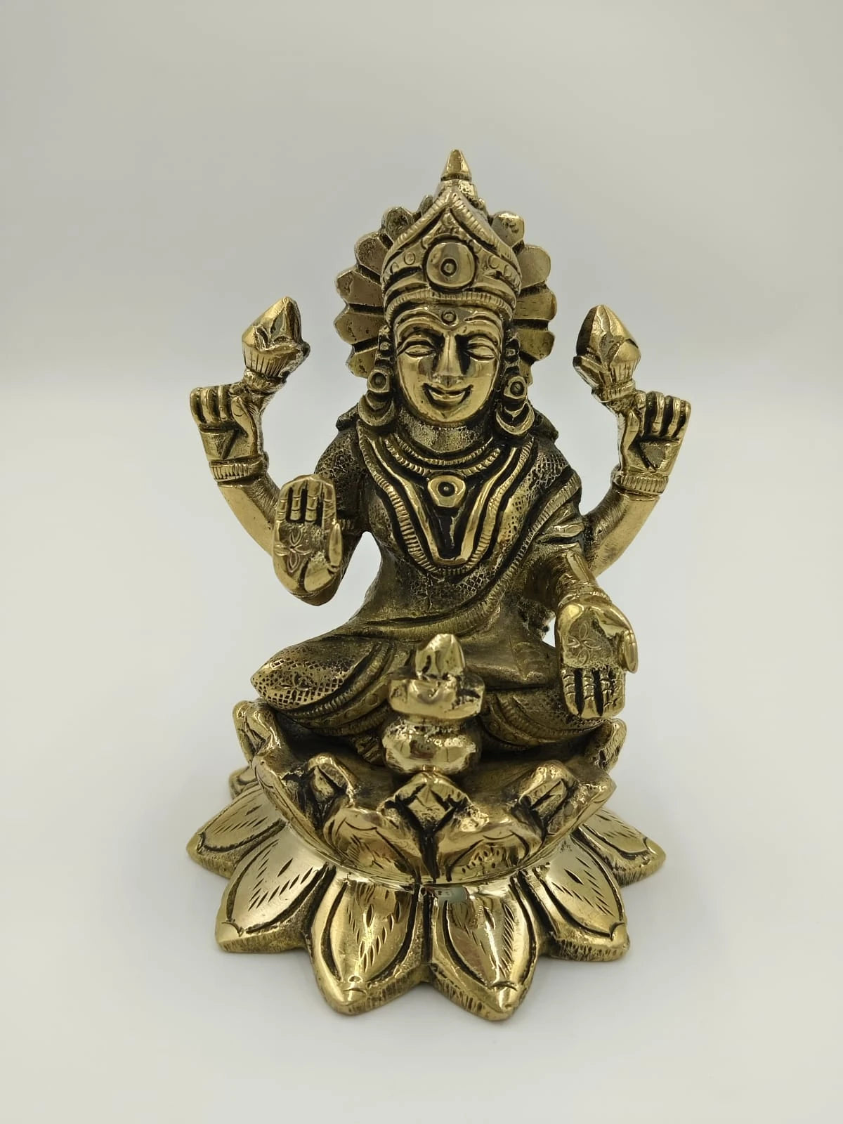 Medium brass Lakshmi statue sitting on a lotus with four arms